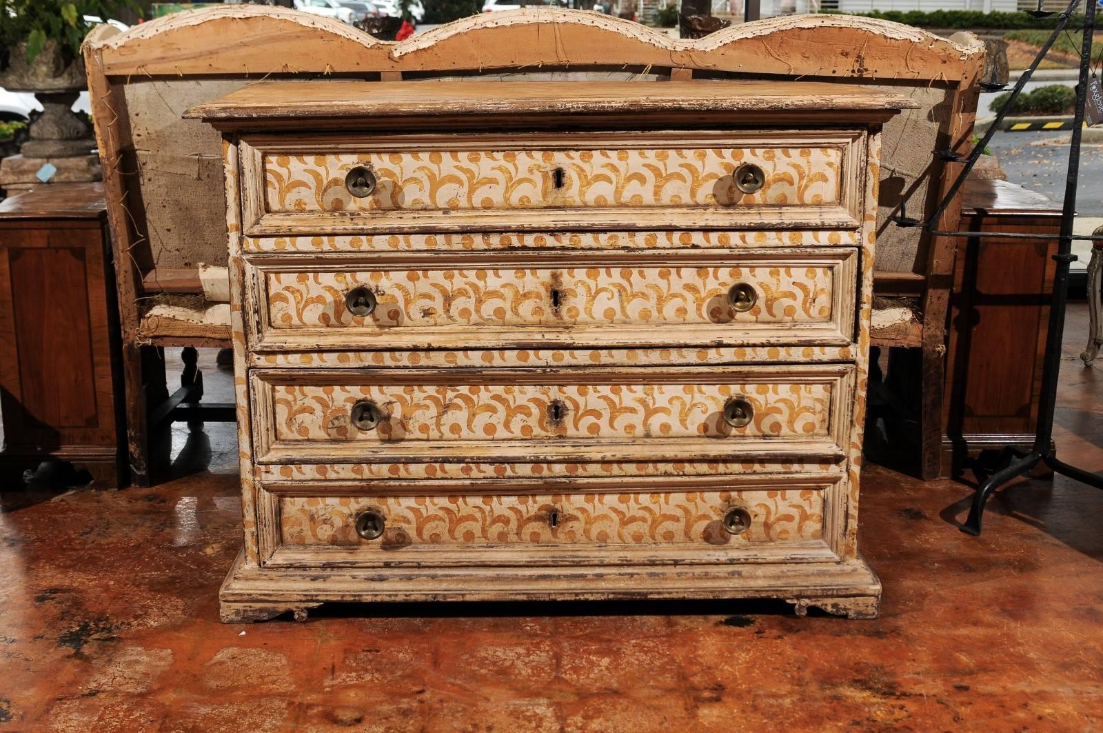 An Italian 17th century Florentine tall wooden four-drawer commode with painted floral motifs. This Italian commode was born in Tuscany, during the later years of the 17th century. Featuring a rectangular top with molded edges, the chest comprises