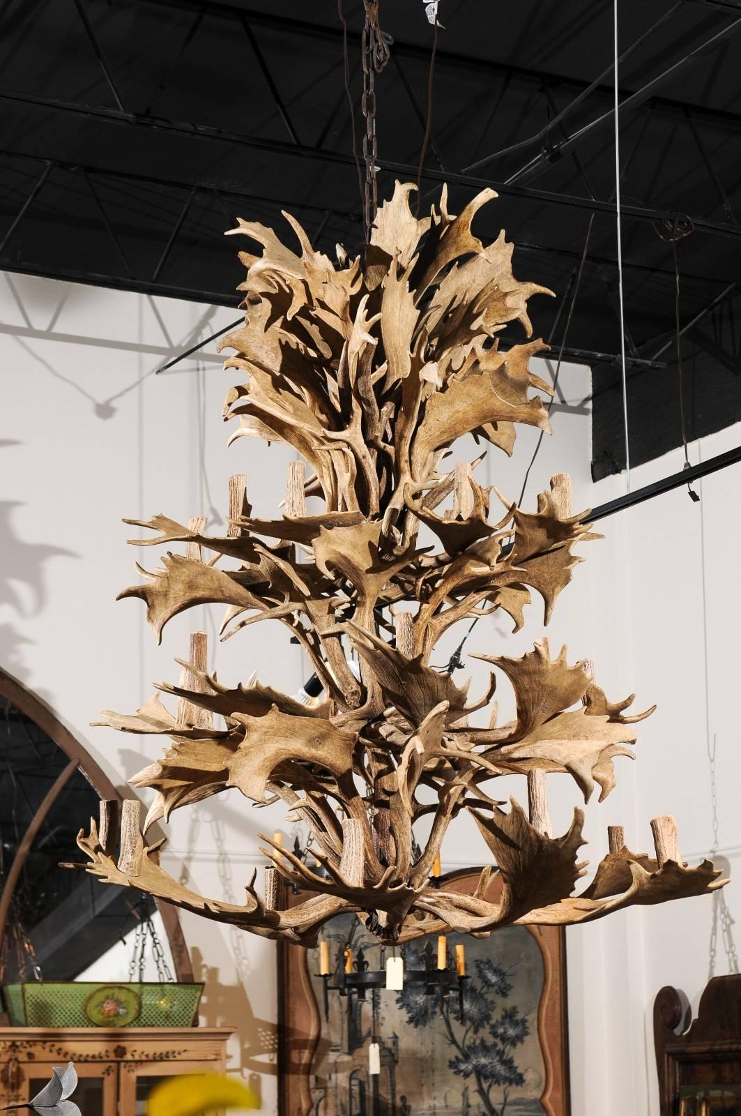 A 24-light continental four-tiered antler rustic chandelier, from the mid 20th century. This light fixture was made of naturally shed antlers in Europe during the 1940s. The tall and striking silhouette comprises four levels, the two lower ones