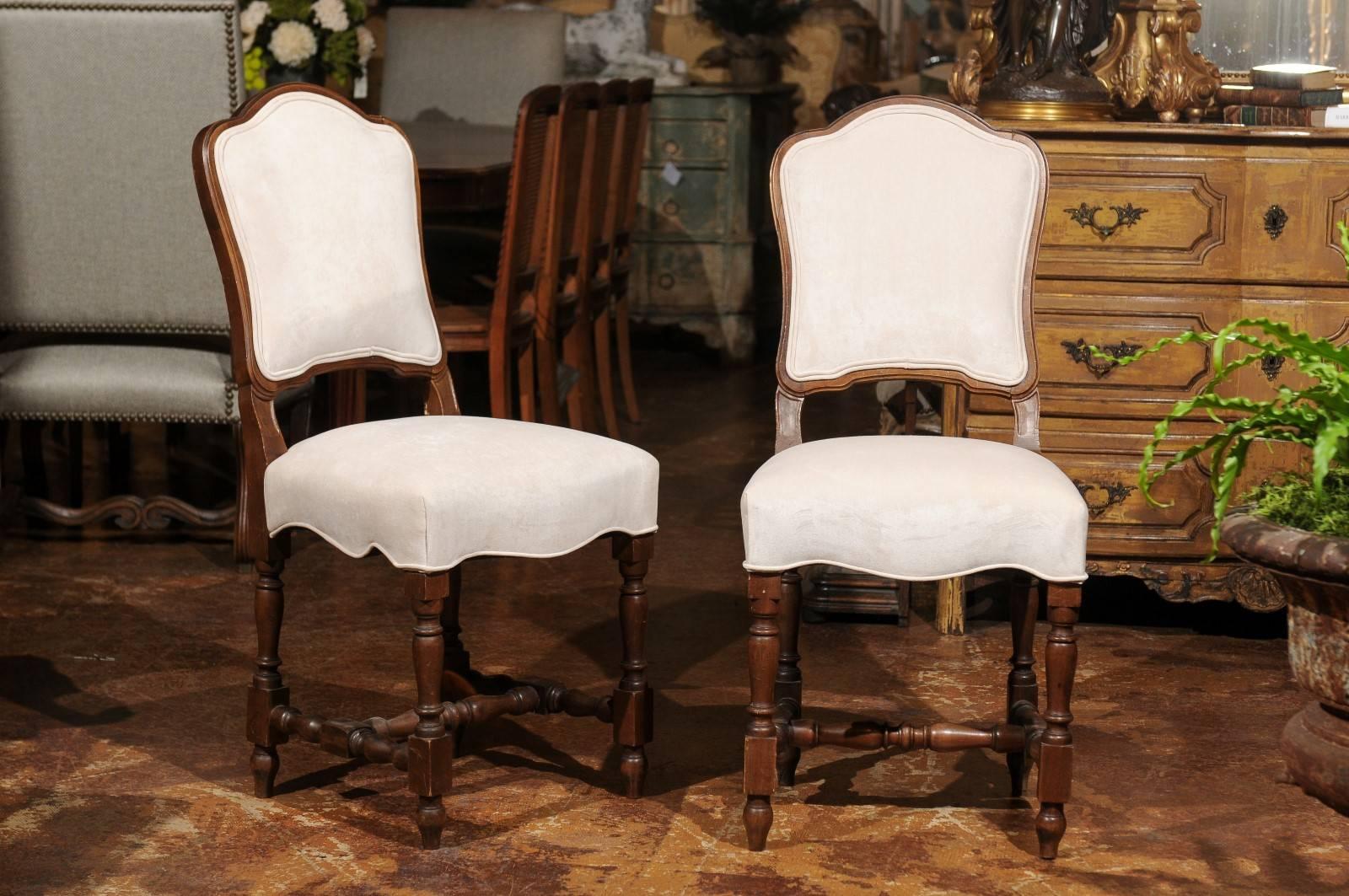 A set of ten French walnut dining room chairs with turned legs from the late 19th century with new upholstery. Each of this set of ten 'chaises à la Reine' features a slightly slanted back with curved upper rail, supported by a rectangular seat with