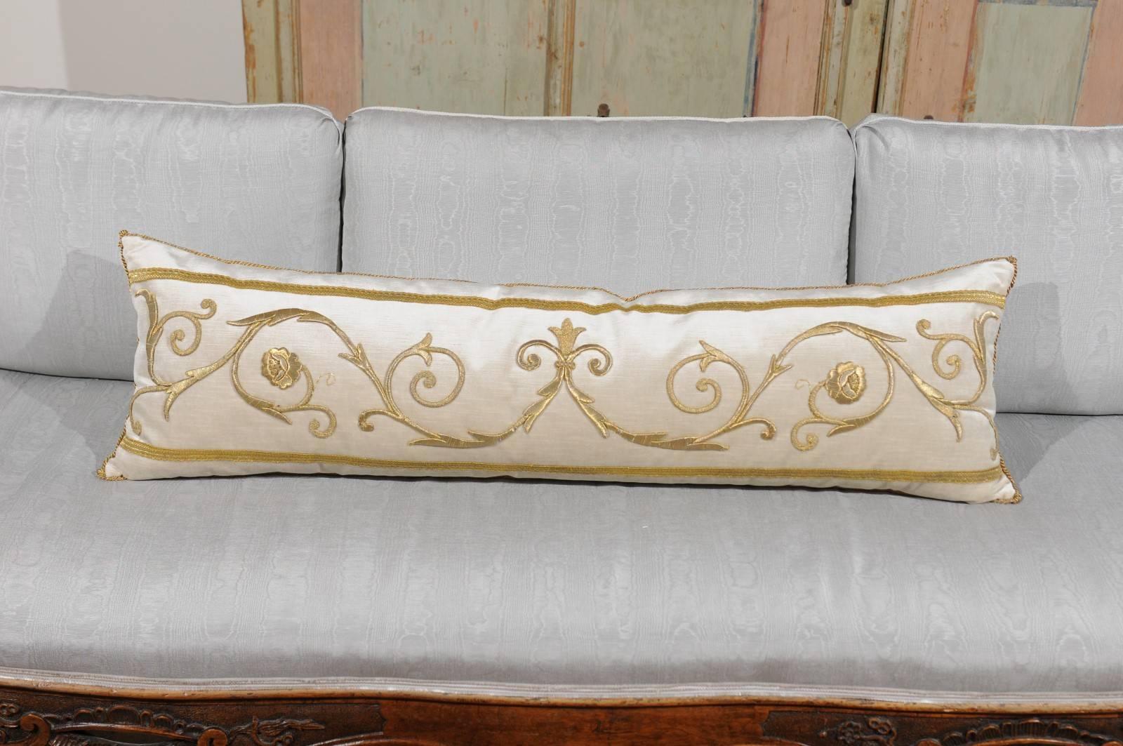 A lumbar cushion made of an antique European raised gold metallic embroidery of scrollwork bordered with antique gold metallic galon on oyster velvet. Featuring a graceful décor of Renaissance style rinceaux standing out beautifully on the subtle