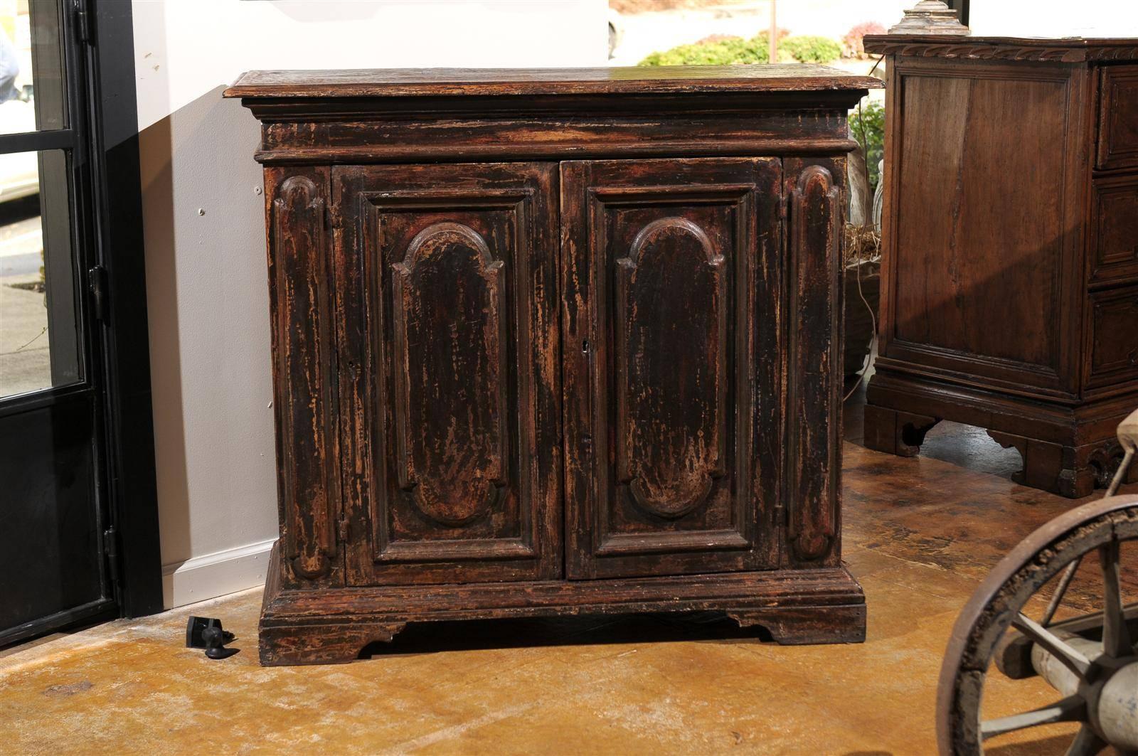 This pair of Italian late 19th century tall painted wood buffets features simple rectangular cornice tops over two doors with carved vertical cartouche-shaped panels, which are echoed on a narrower scale, on the sides. A functioning key unlocks the