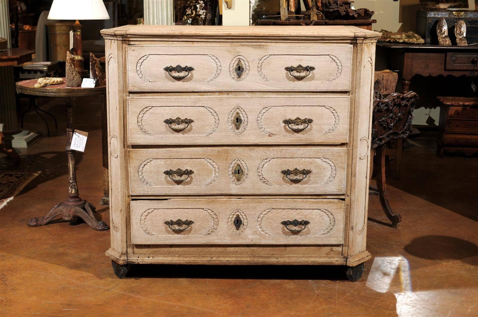 19th century Belgian bleached commode, the rectangular top with canted corners surmounting four long drawers and raised on ball feet.