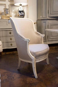 Pair of French 19th Century Barrel Back Upholstered Wing Chairs with Saber Legs
