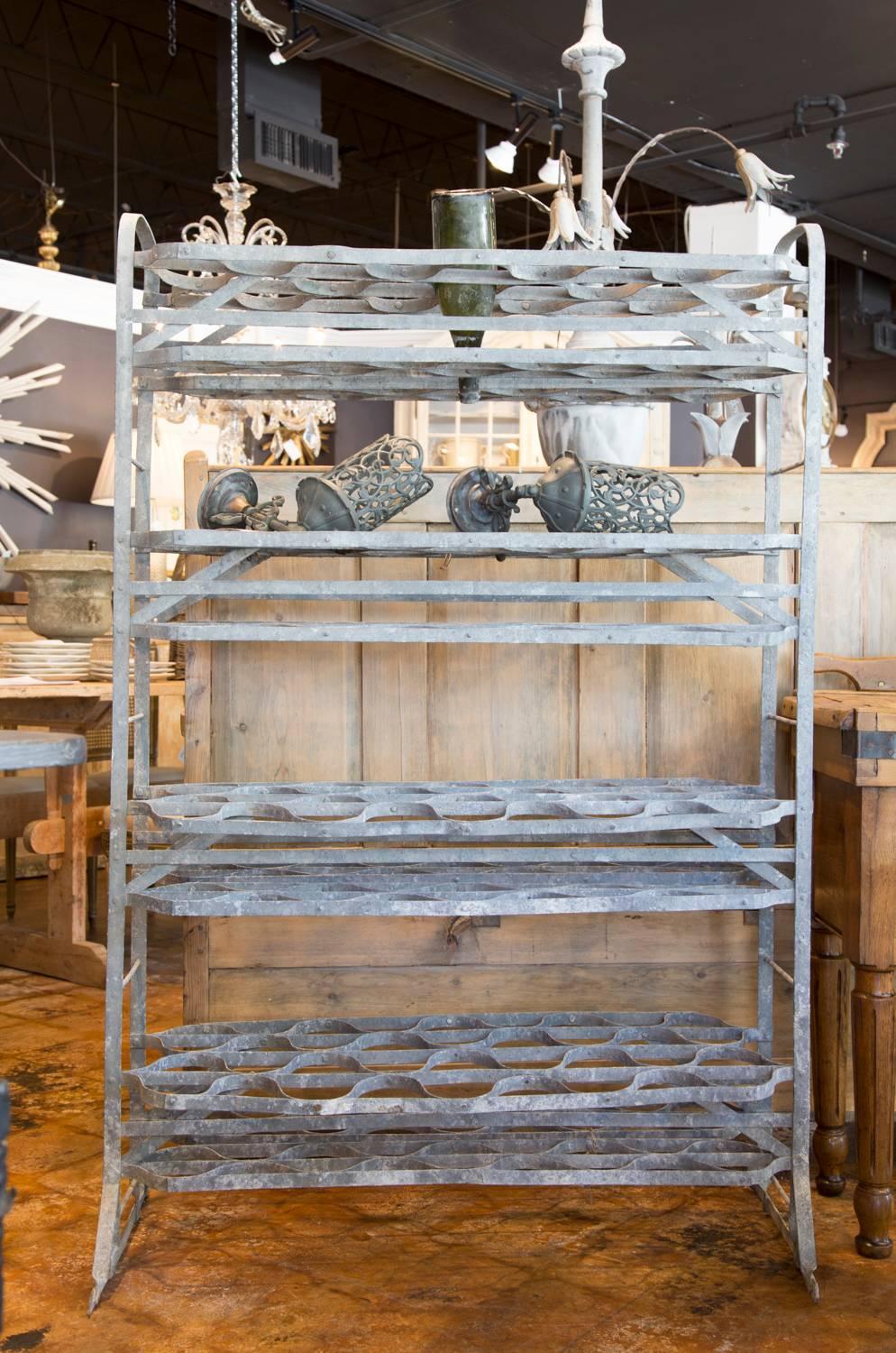 This French zinc tiered bottle rack was traditionally used in a wine cellar to dry out bottles that had been rinsed out to reused. Having a capacity for holding in excess of 100 bottles upside down, it could also be used to support terracotta pots