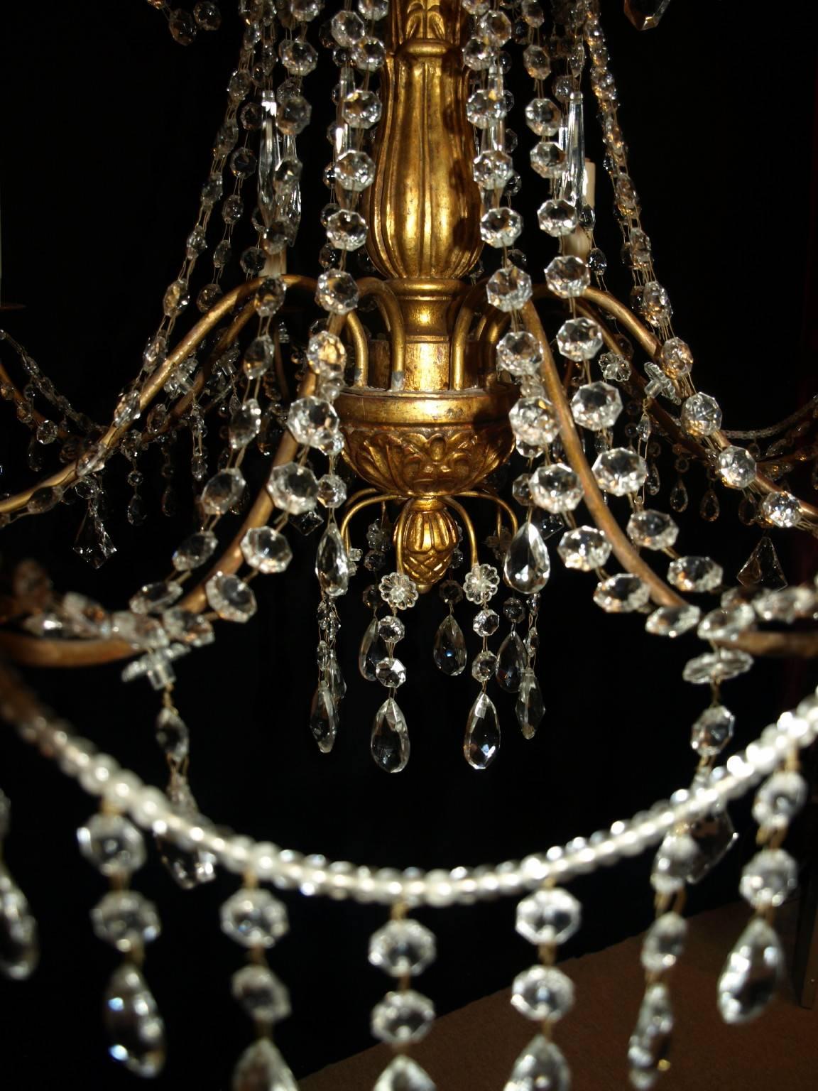 Late 19th century giltwood, iron and crystal Genovese chandelier originally for candles. Eight lights.