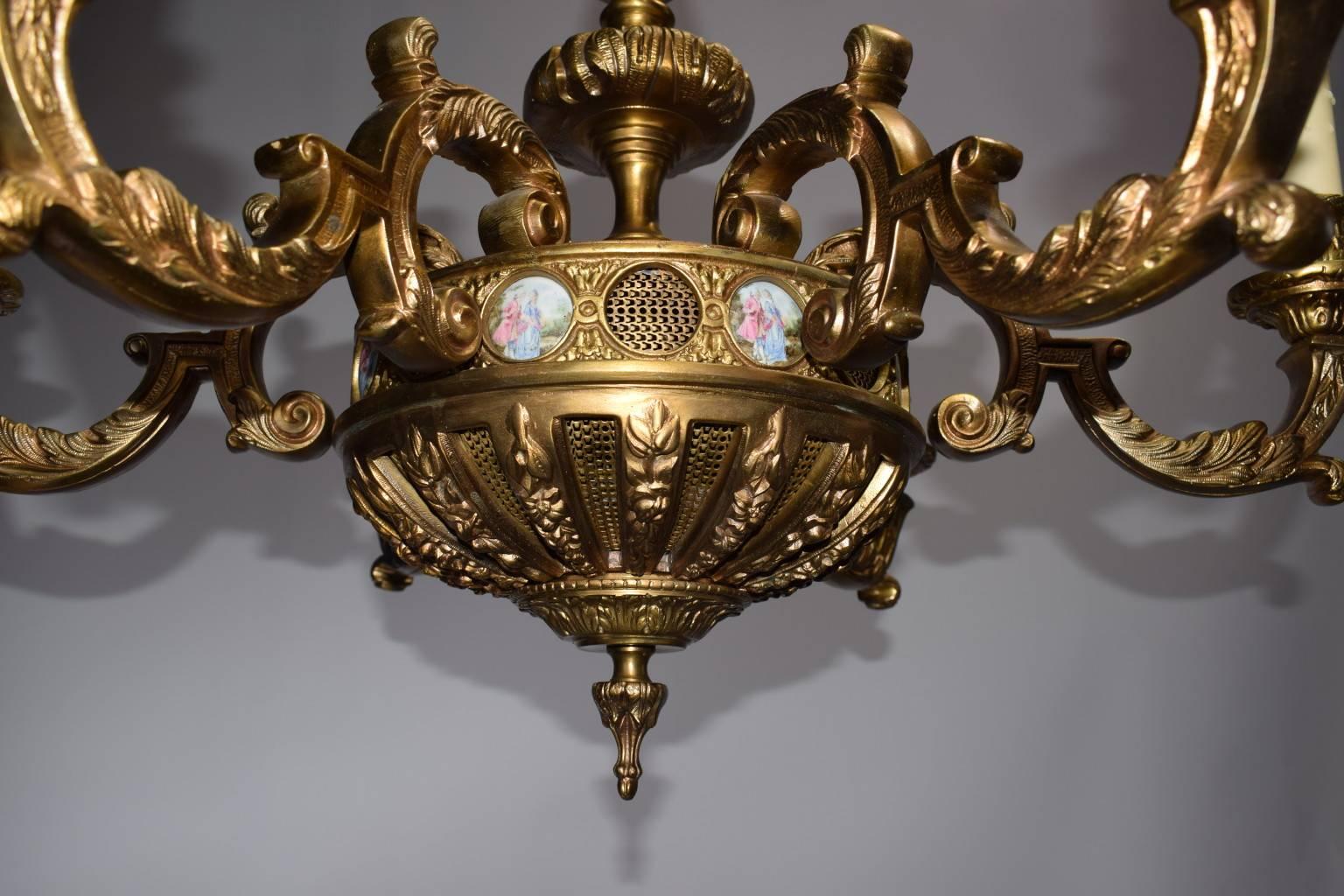Neoclassical gilt bronze six-light chandelier having decorative porcelain plaques.