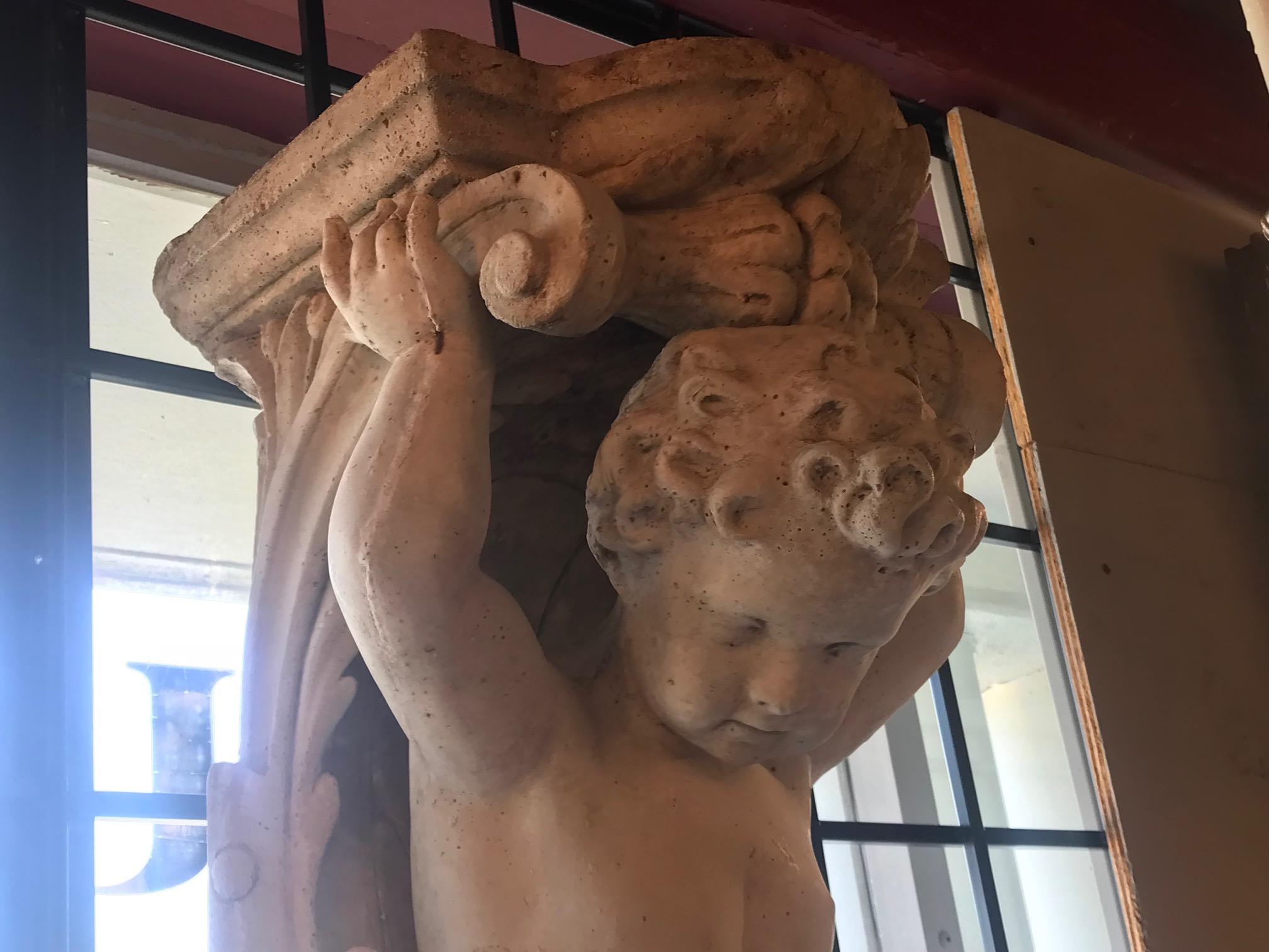 Pareja de ménsulas figuradas de piedra fundida de estilo clásico. Cada una representa a un niño que sostiene un estante de pastores con guirnaldas.
Dimensiones: Altura 48