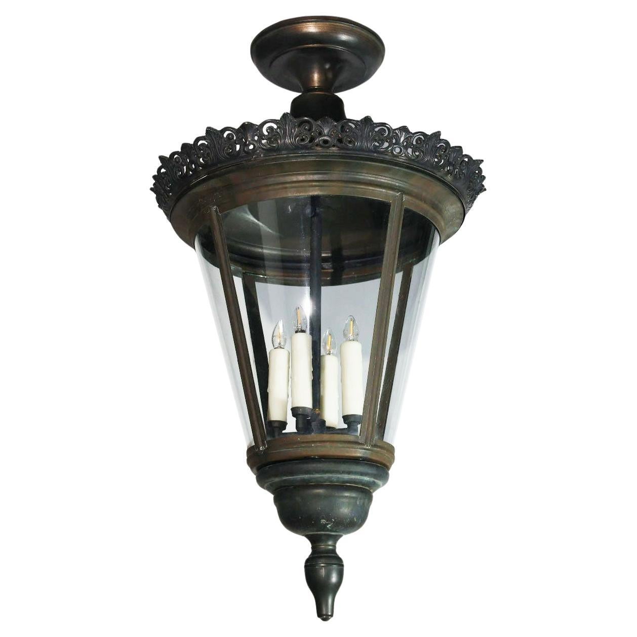 Élégante lanterne en bronze avec des panneaux de verre incurvés.