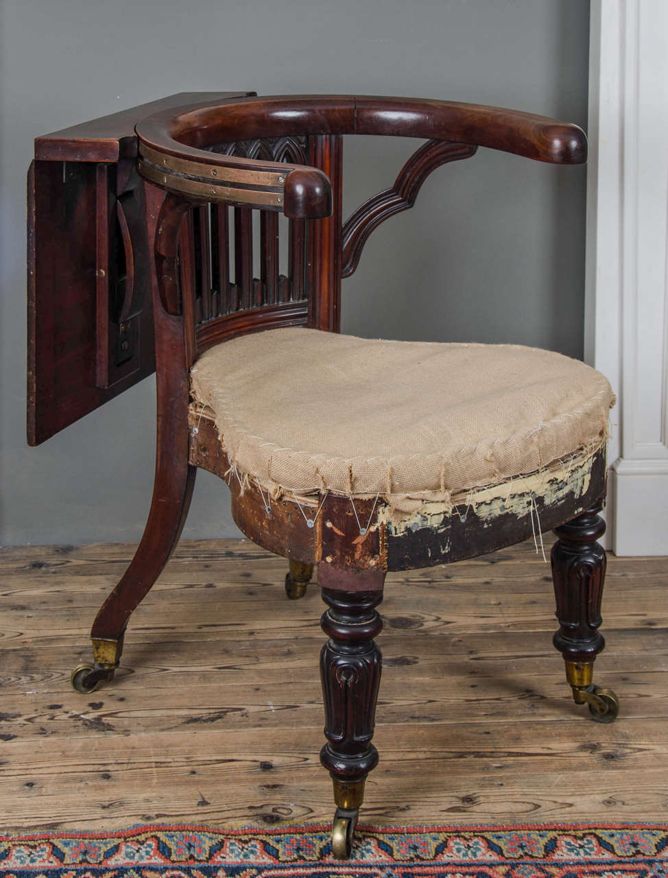 With Gothic arch carved backrest, on turned tapering legs with brass caps and casters, English, circa 1810.