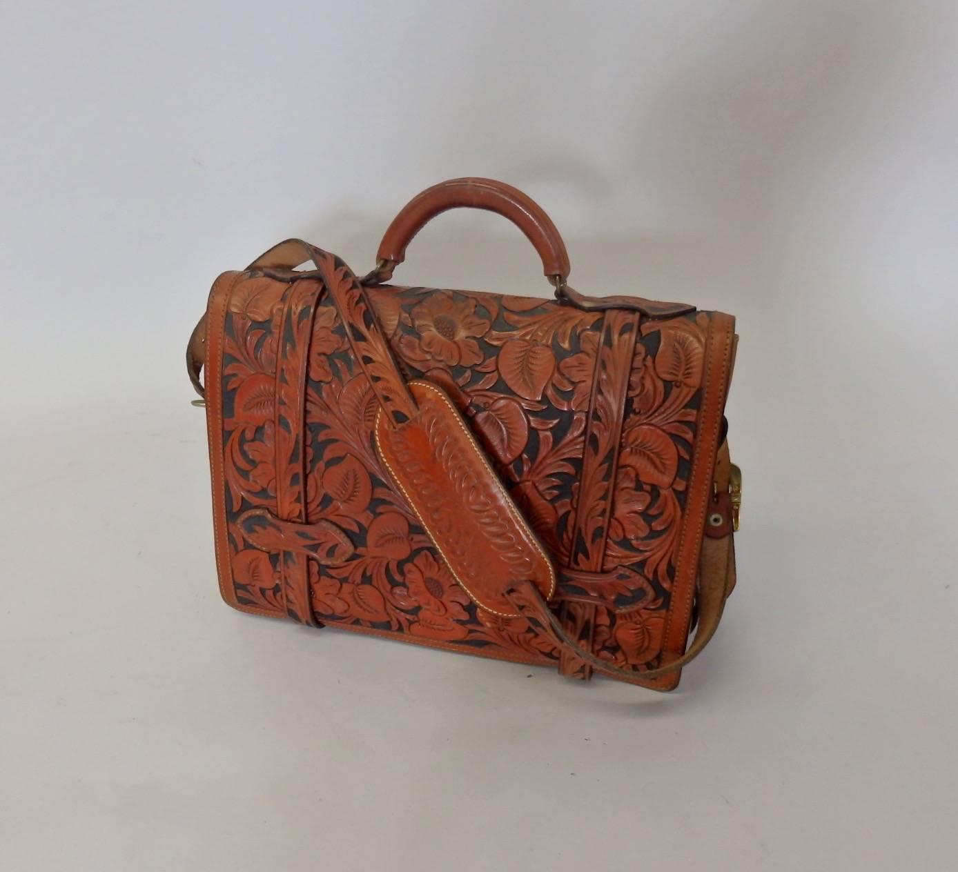 Beautifully leather briefcase completely tooled including straps and shoulder pad. Crafted by Afonso Holster and Gun Shop Hollywood Ca. For the cowboy that has everything. Patina to the brass hardware, original key included.