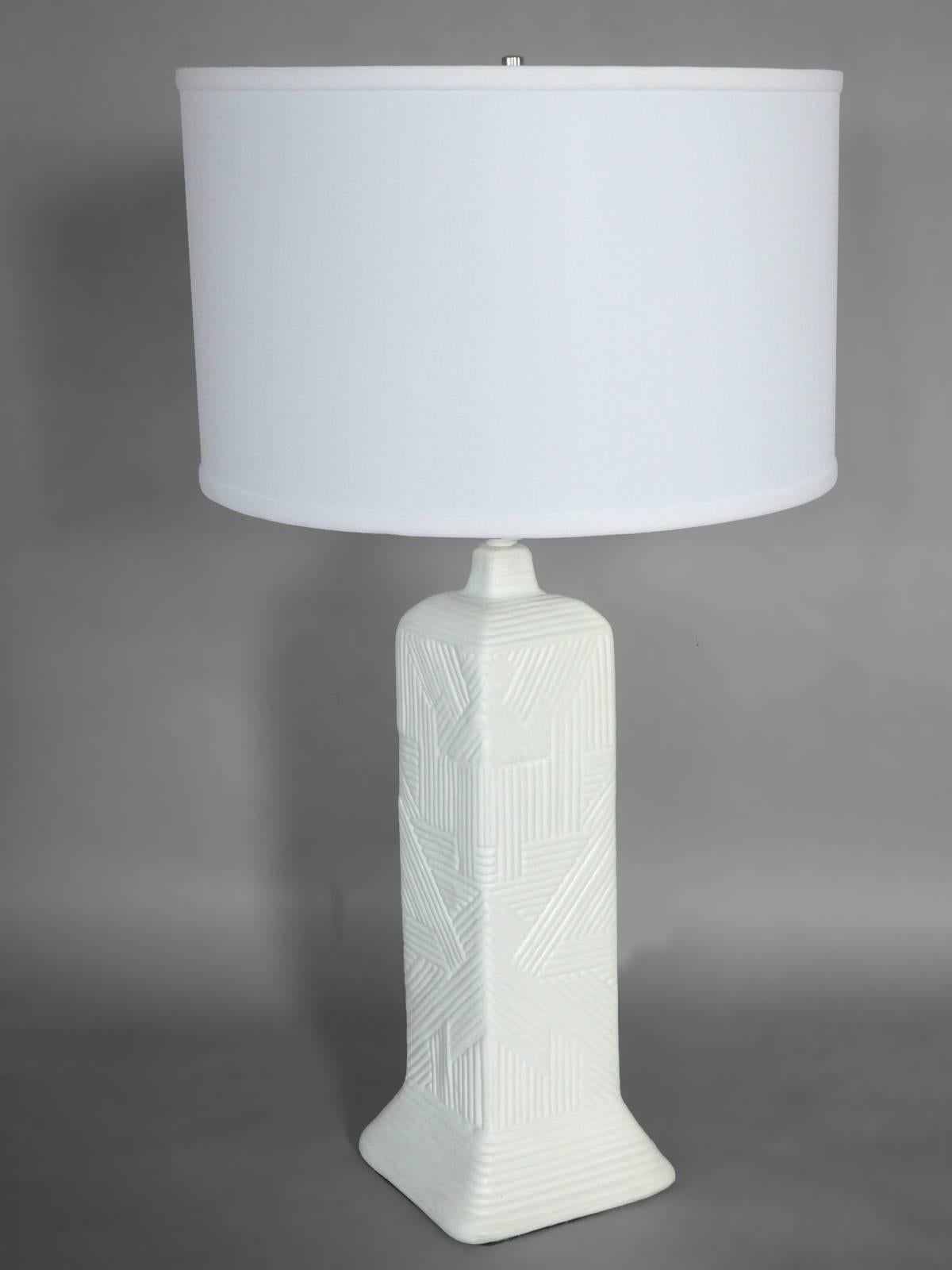 Pair of matte white Art Deco inspired table lamps . Skyscraper styled table lamps with cubist geometric decoration . Lamp body measures 19.5 tall ,  23.5 tall to top of socket ,  Total height to top of Harp 31