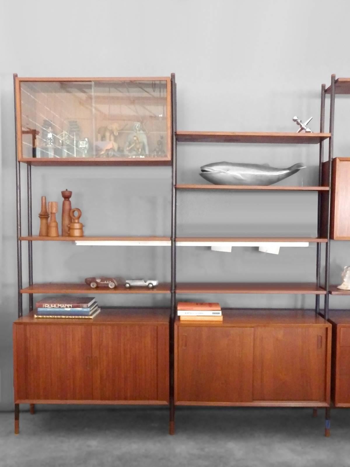 Attributed to Arne Vodder for Sibast Mobler, steel frame with teakwood legs shelves , cabinets , and top caps.
Cabinets and shelves can be configured in numerous ways to face either side for room divider effect, shelves are 12” deep.