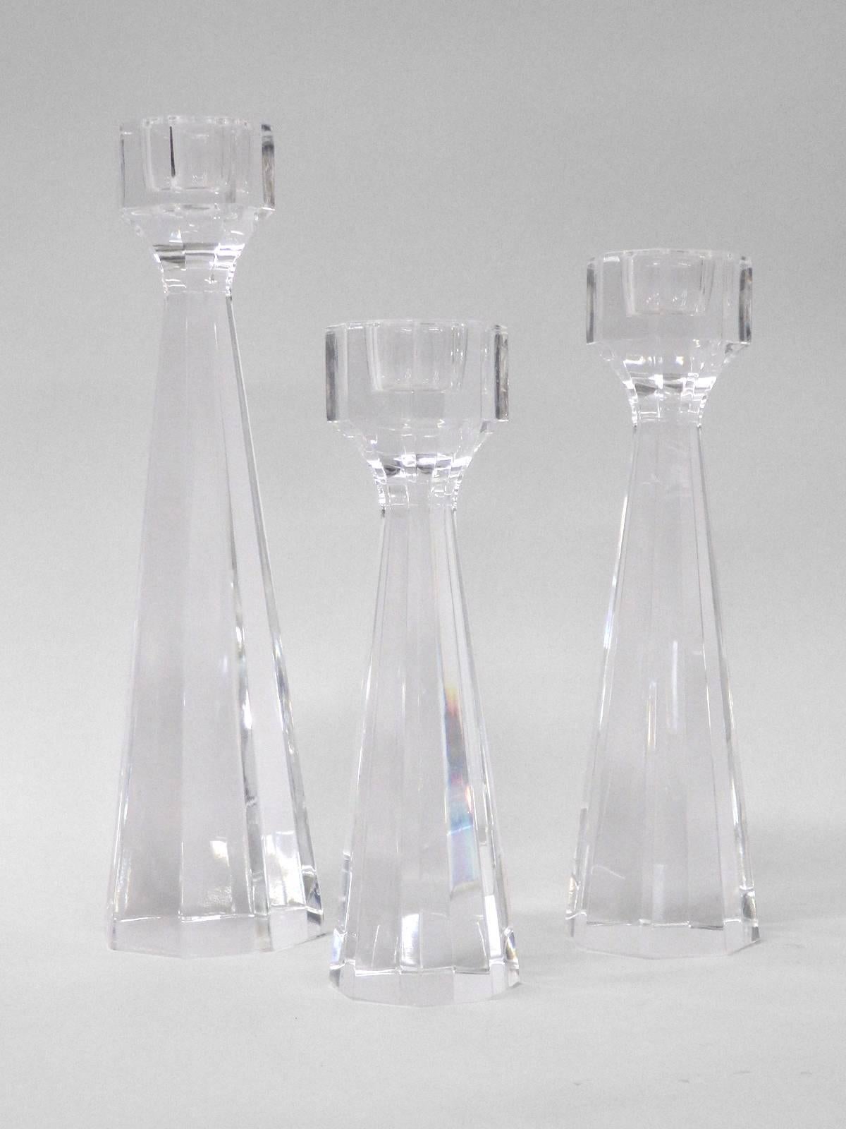 Set of three lead crystal candle sticks . Designed by Eden Falk for Kosta Boda.  Eight faceted sides form the octagon shape . Signed Kosta Eden Falk 
Tallest: 2.75” wide at base x 2.75” deep x 10” tall. Second 8.5 tall x 2.25 wide at base smaller