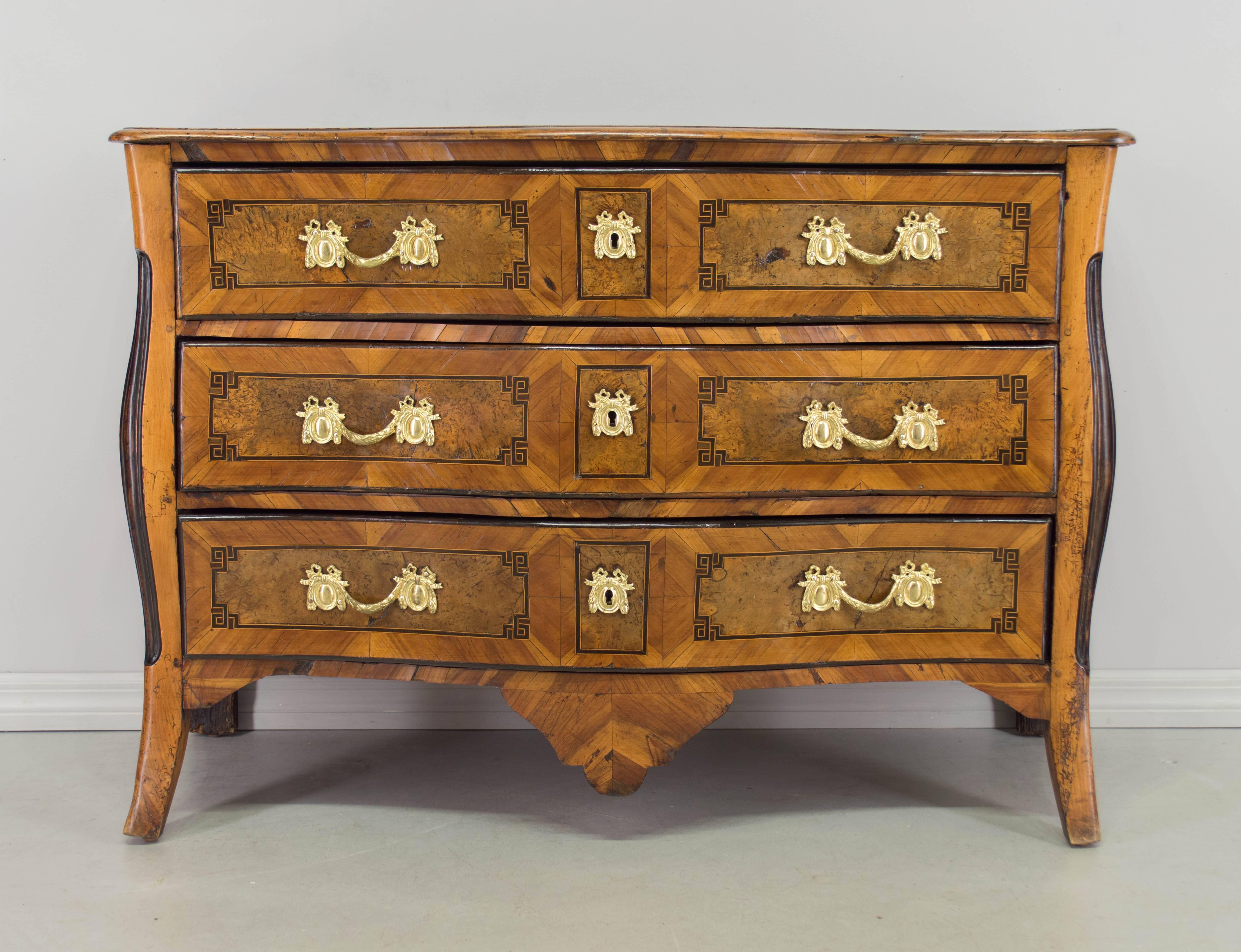 18th century Louis XV commode from Grenoble with exceptional craftsmanship and beautiful inlay work. Serpentine front with three drawers inlaid with burl of walnut outlined with ebonized details. Original polished bronze hardware. Curved sides