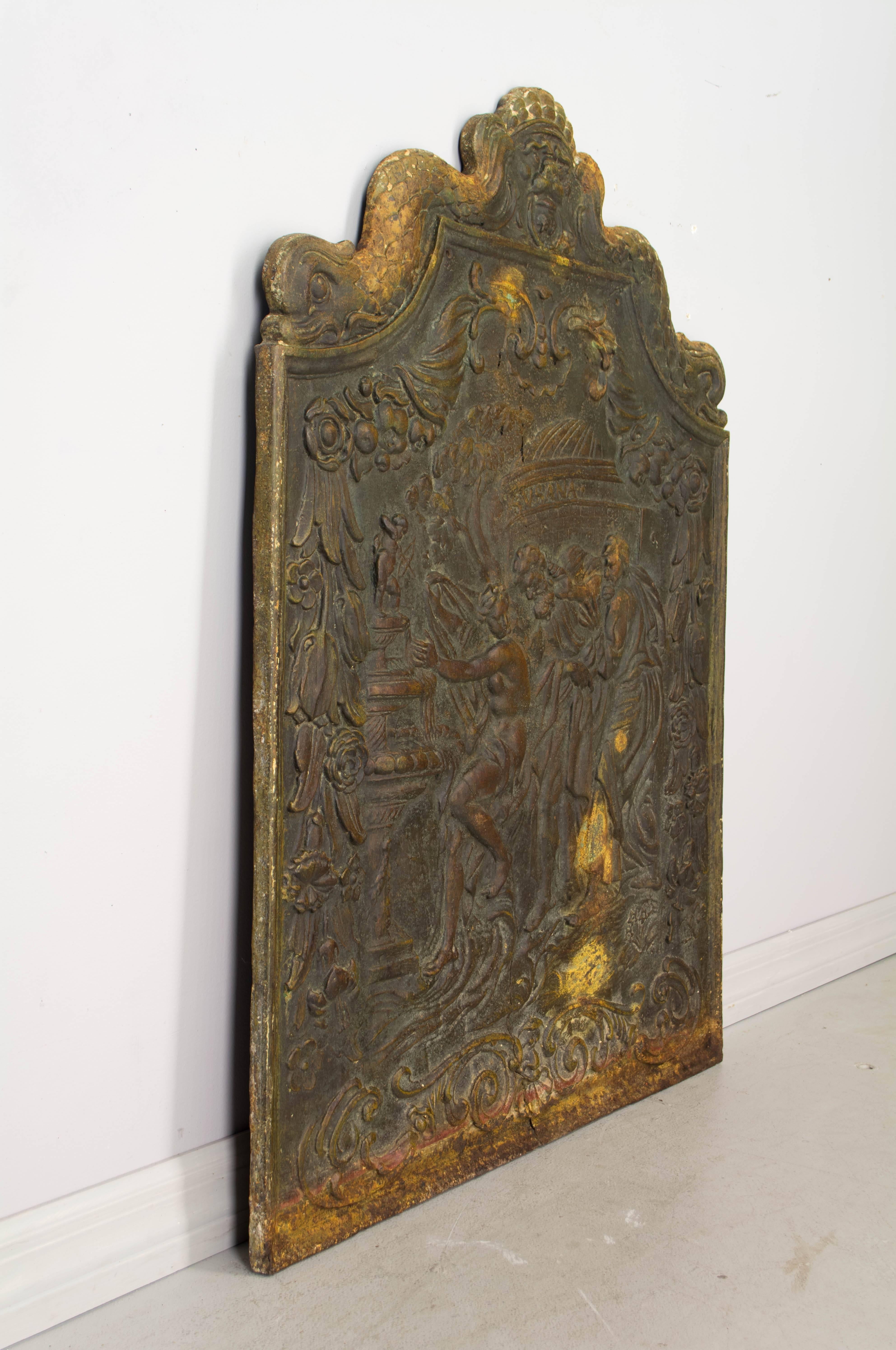 18th century French cast iron fireback depicting Susanna and the Elders. Expert casting with detailed relief and shaped crest. Notice the crack from the bottom left of center.
Contact us for a competitive shipping quotation. Please refer to photos