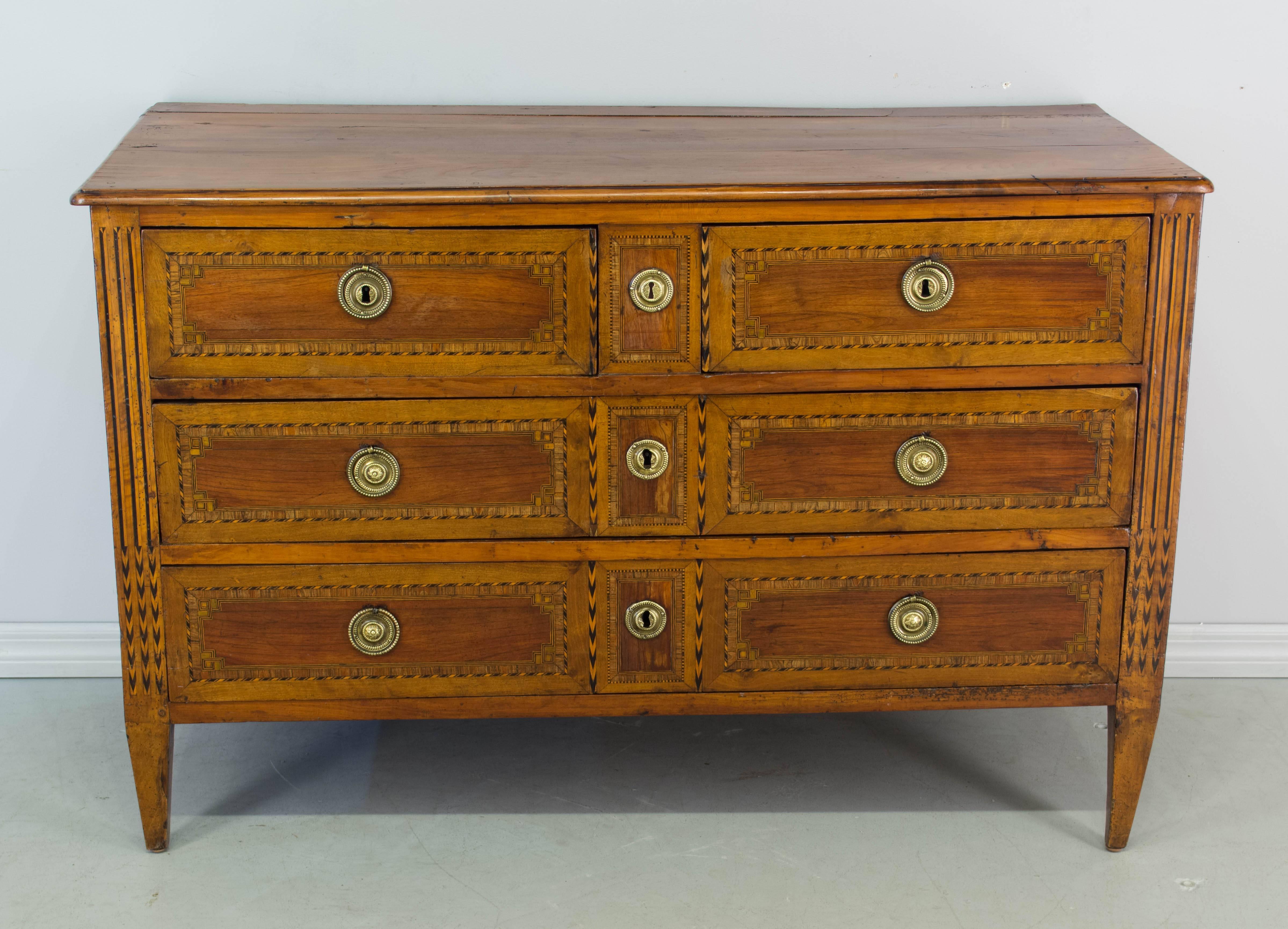 18th century Louis XVI marquetry commode made of solid cherry. Four dovetailed drawers with inlay of walnut and mahogany. Original brass hardware with locks in working order and one key. French polish finish. Oak and pine as secondary wood. Bottoms