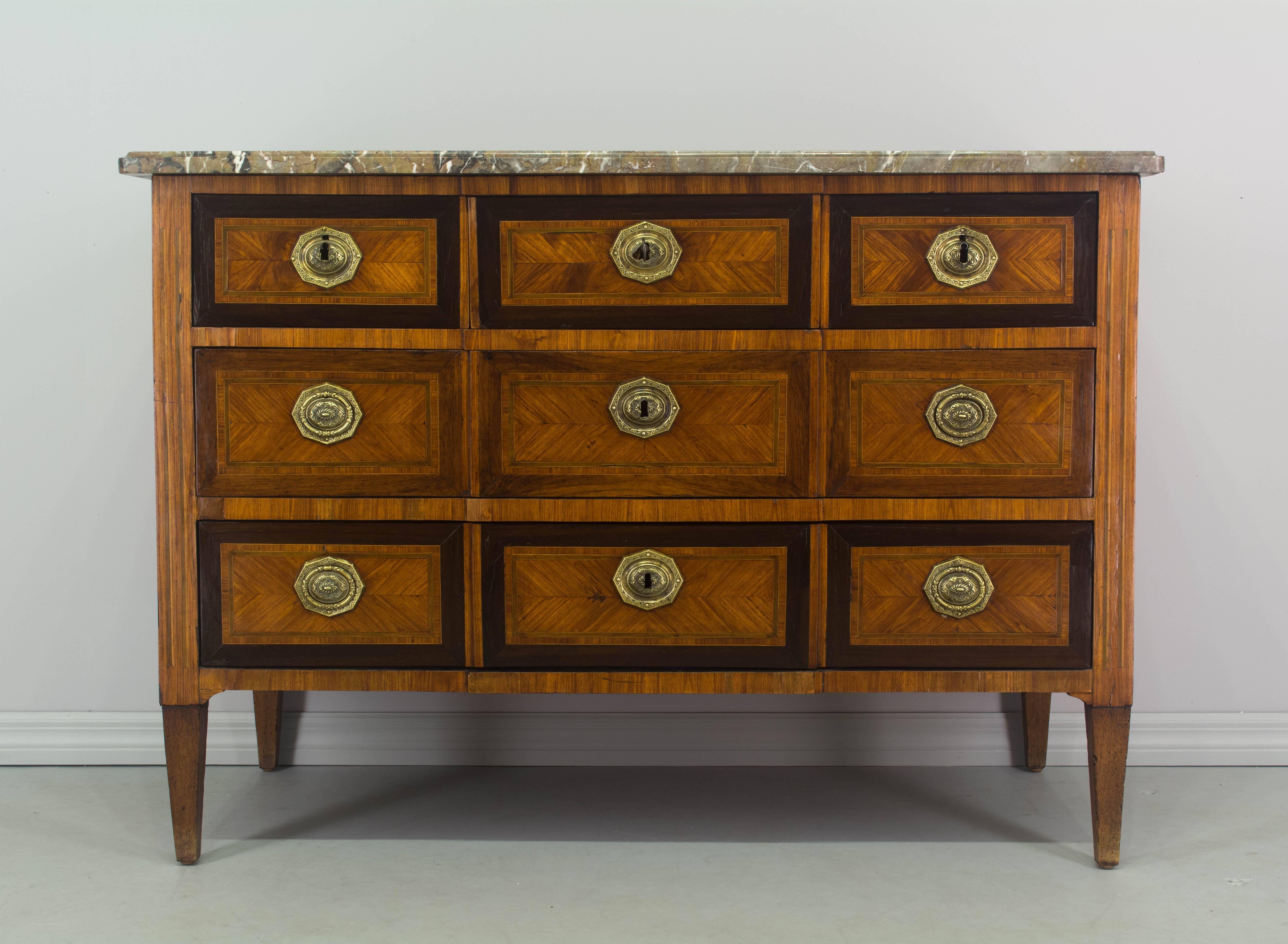 18th century Louis XVI commode inlaid with veneers of walnut and mahogany with pine as a secondary wood. French polish finish. Five dovetailed drawers with original brass hardware. All drawers have working locks with one key. The left and right top