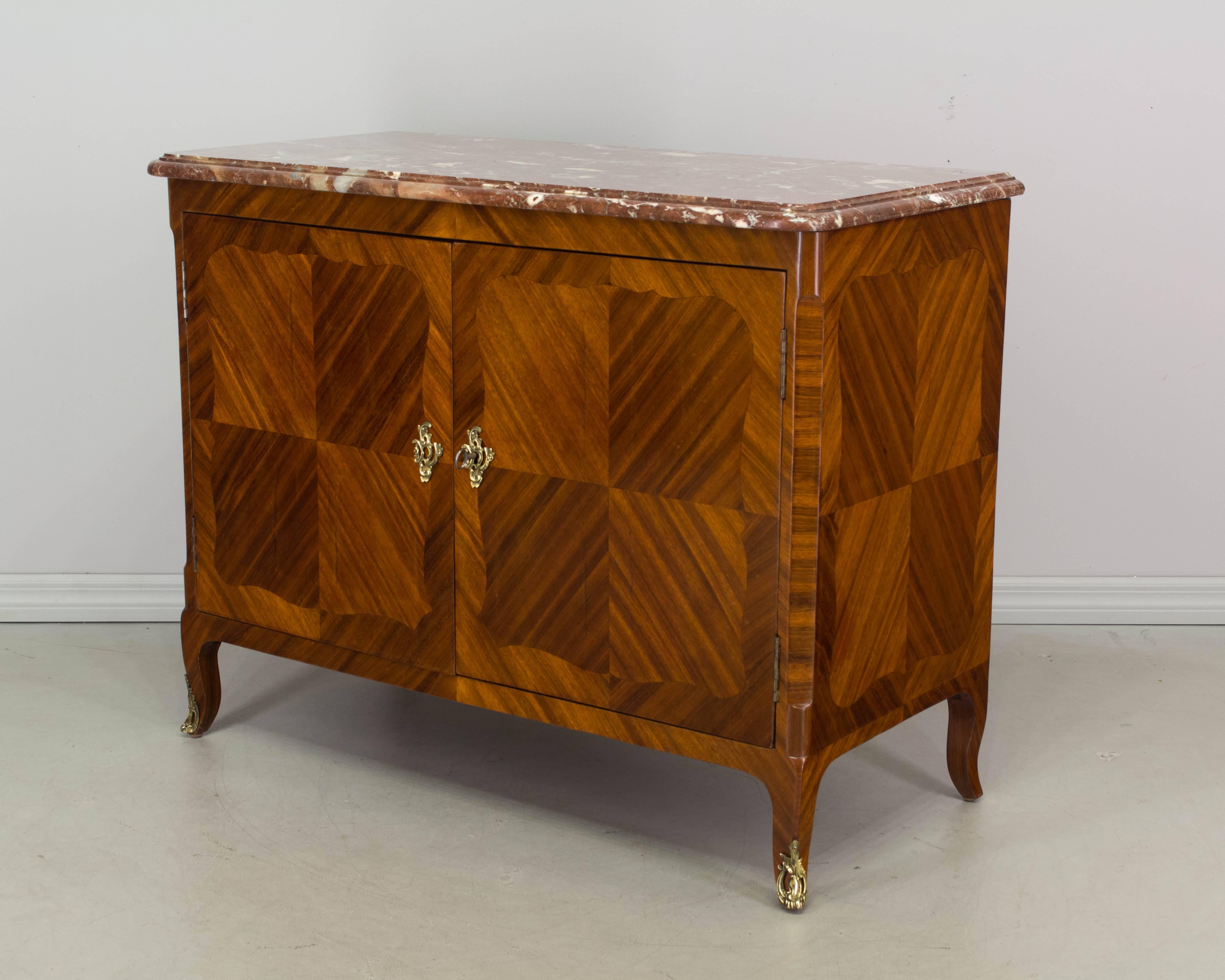 An elegant 19th century Louis XV style Parisian marquetry buffet, finely crafted with bookmatched veneer of mahogany and French polish finish. Beautiful original Rouge Royal marble top. Original bronze hardware with working lock and key. Nice