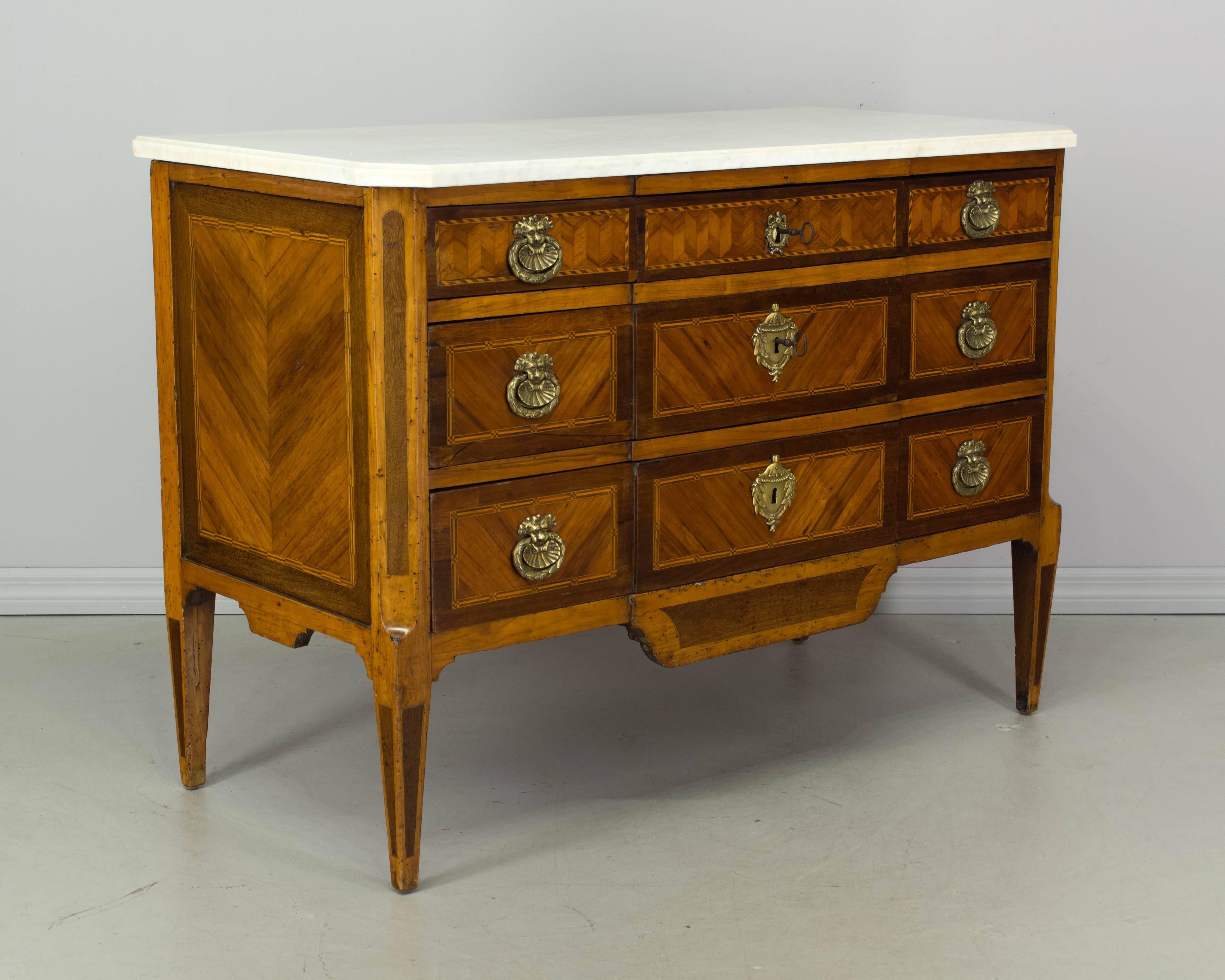 18th century French Louis XVI marquetry commode with veneers of mahogany, walnut and cherry. French polish finish. Pegged construction with mortise and tenon joints. Five dovetailed drawers with original bronze hardware. Locks are in working order