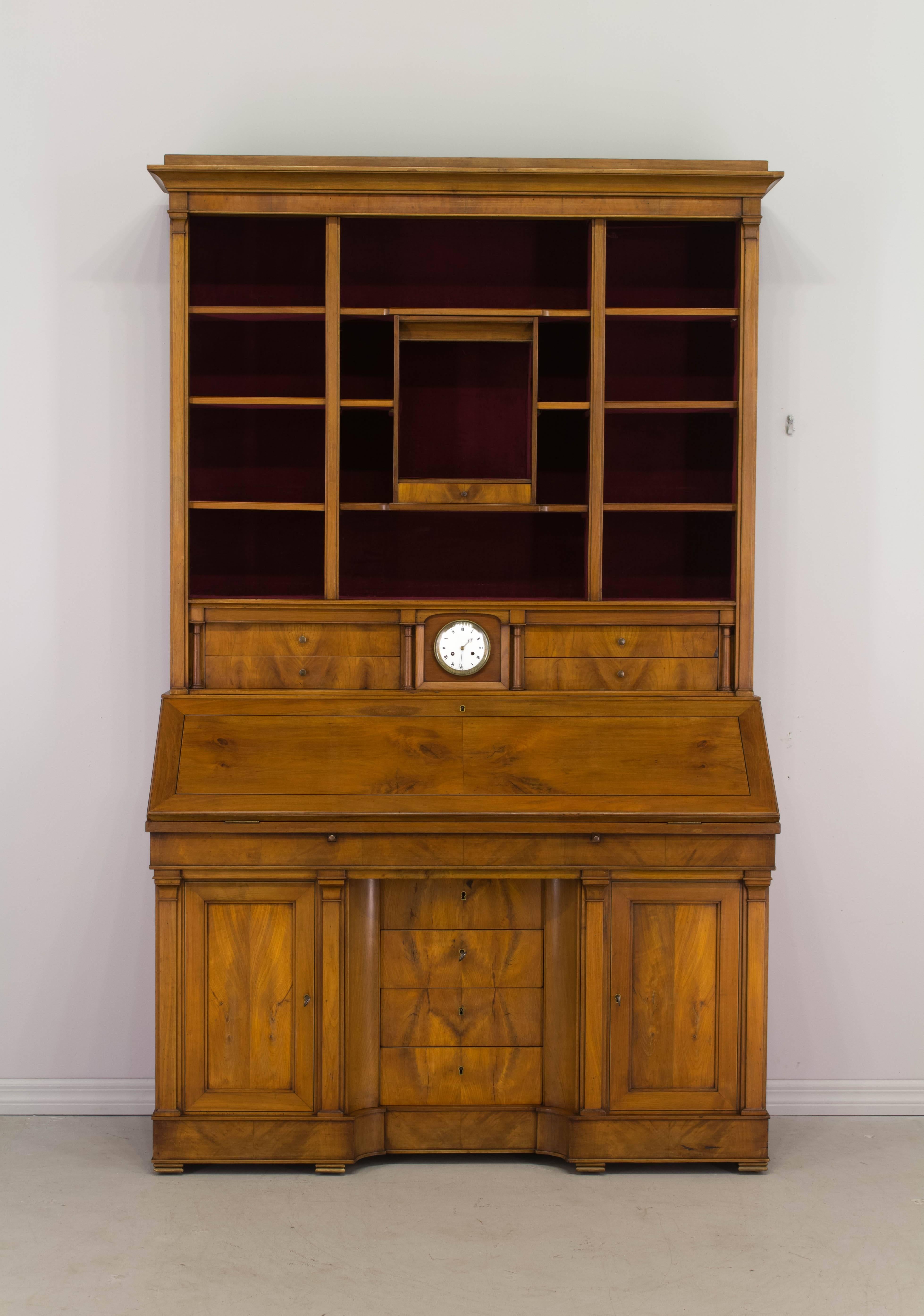 An early 20th century French scriban bibliotheque, made of solid cherrywood with veneer of cherry used as a decorative element on the face of the drawers. From the Loire Valley, this secrétaire was custom built and has several secret compartments.
