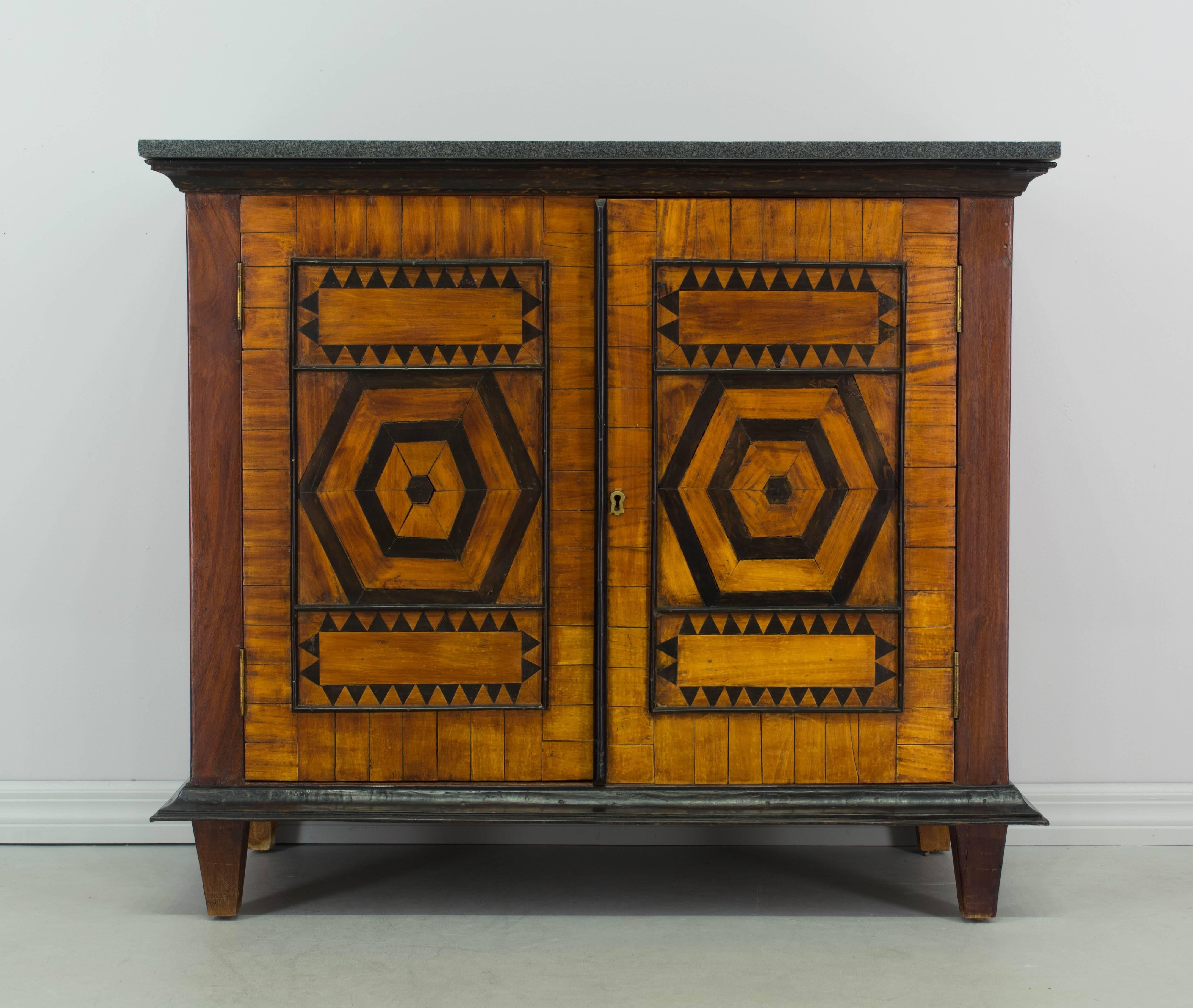 An unusual French Art Deco buffet made by an artisan ebeniste. Solid mahogany with inlaid cherry and ebonized wood decoration. Original grey marble top. Working lock and key.
More photos available upon request. We have a large selection of French