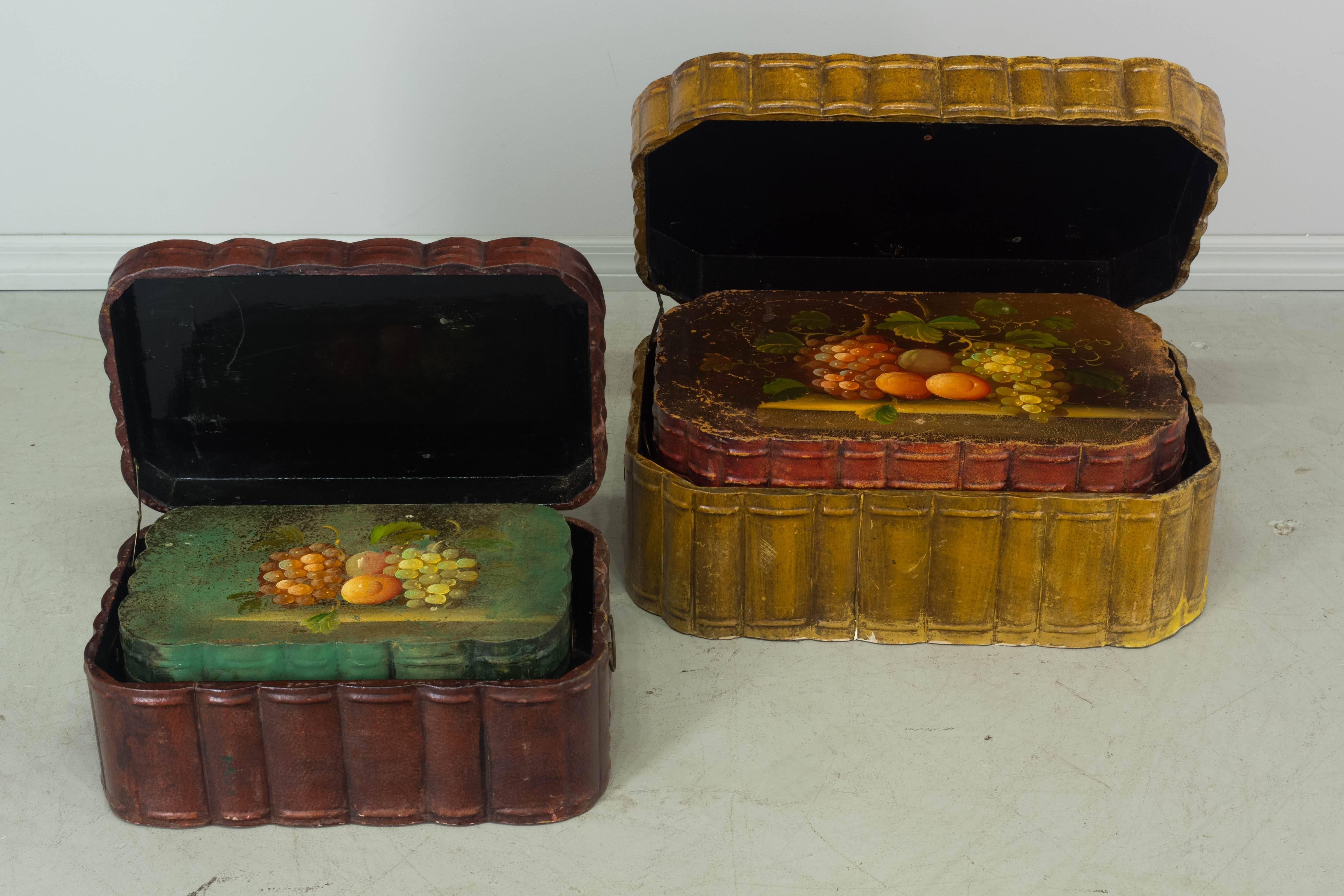 Set of five country French nesting boxes each storing neatly one inside the other. Hinged lids are decorated with still life oil paintings of grapes and fruits. Made of wood covered in leather with black lacquered interiors and brass handles. The