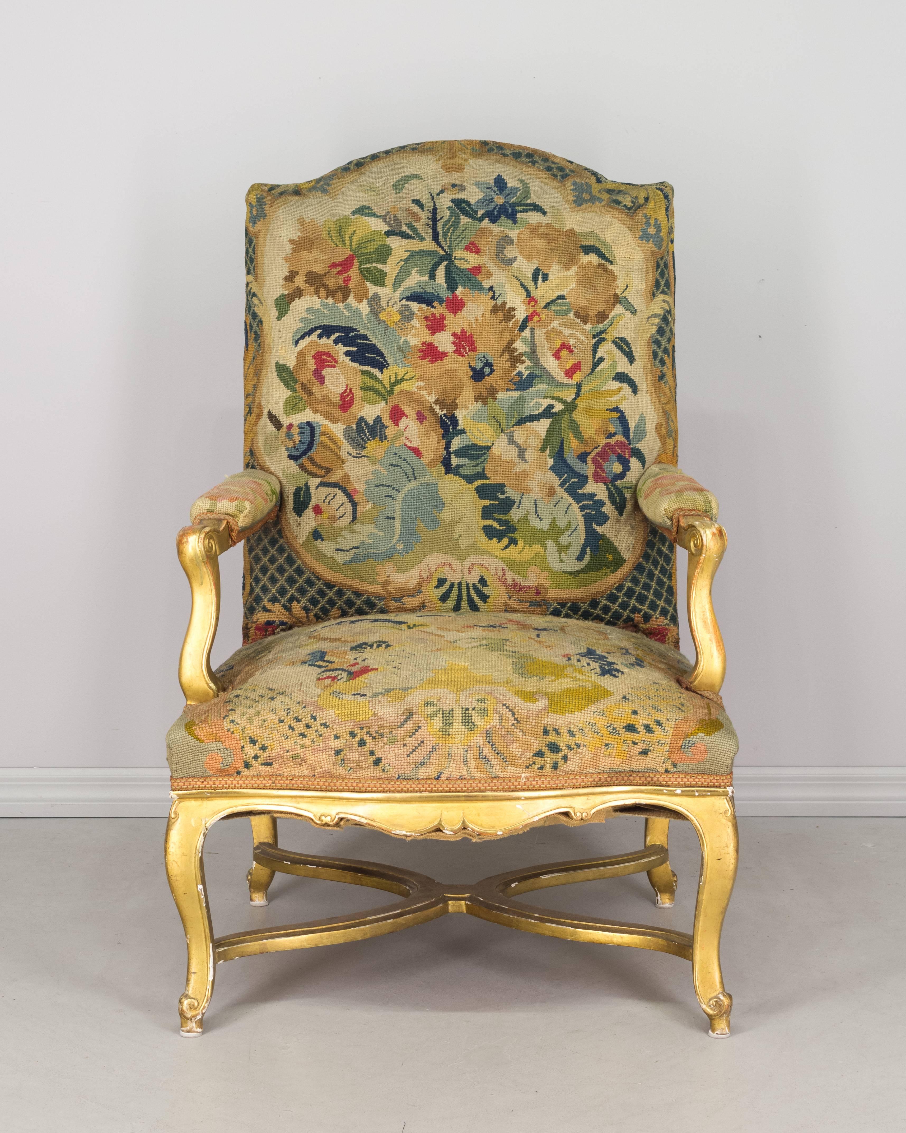 A 19th Century French fauteuil or armchair with gilded wood frame and upholstered in original petit point tapestry.