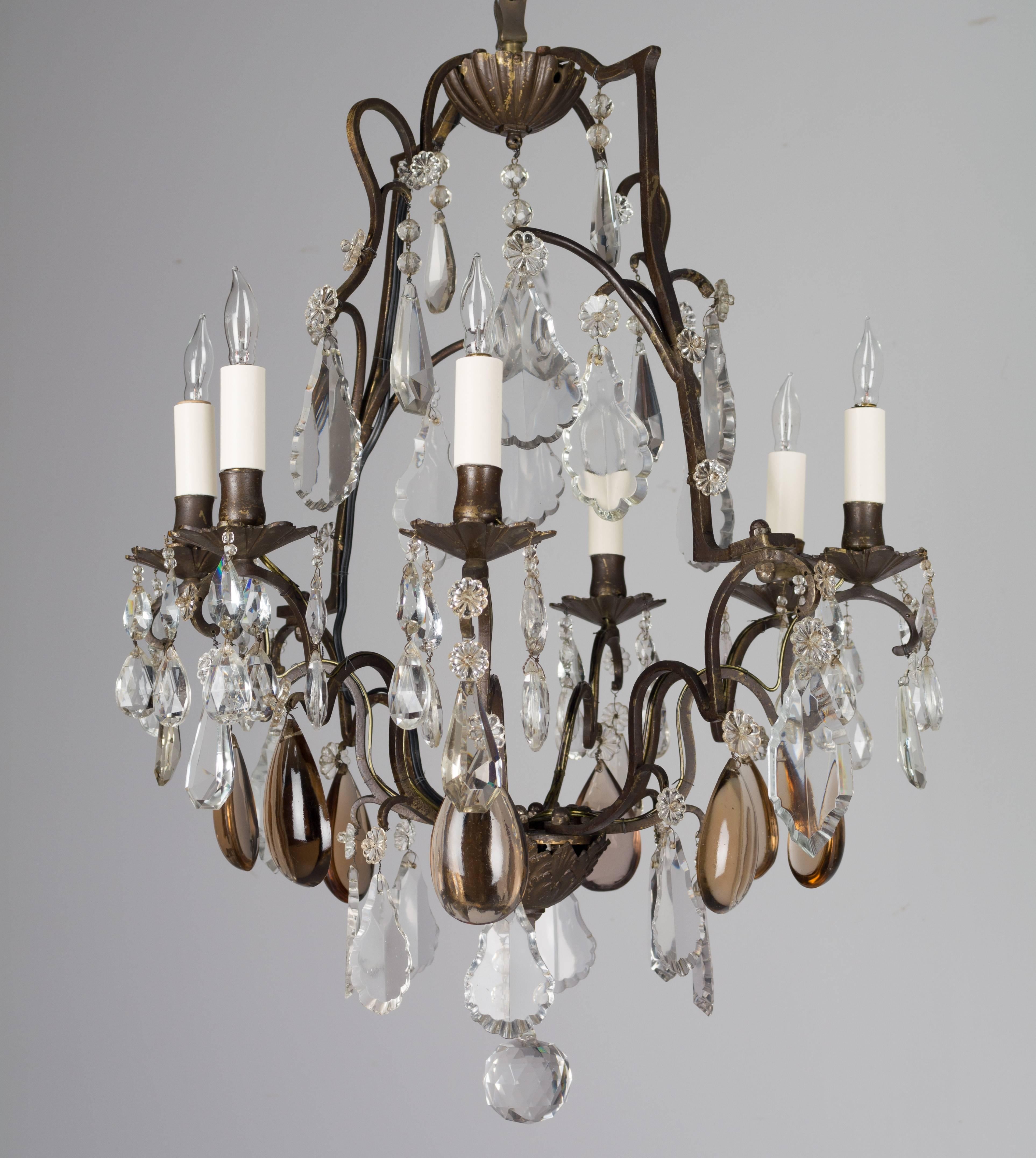 19th century French six-light chandelier with a variety of faceted crystal prisms, rosettes and large amber glass pendalogues. Retaining the original patina. Rewired with American sockets.
More photos available upon request. We have a large