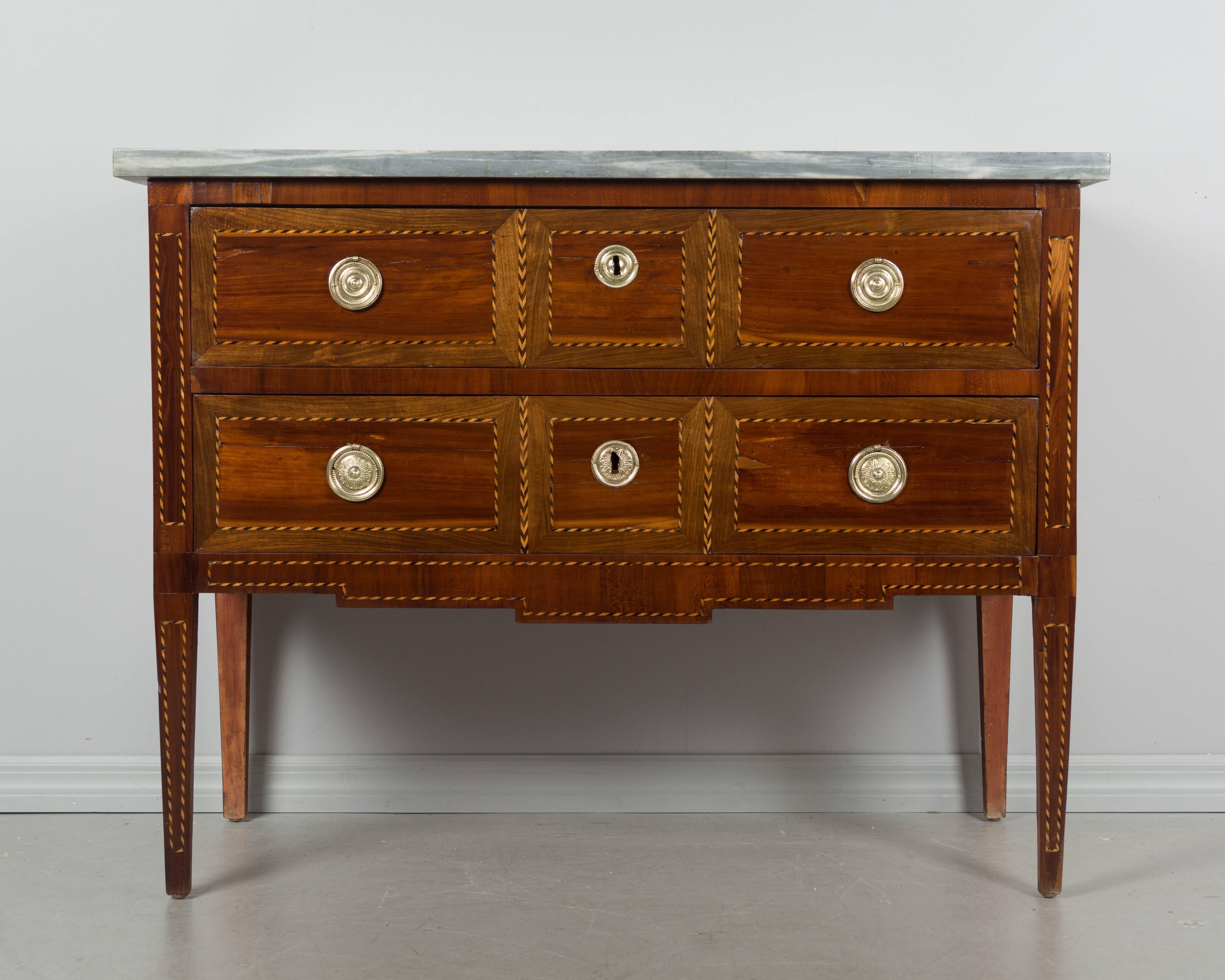 18th century French Louis XVI marquetry commode with veneers of mahogany, walnut and cherry. Nice proportions with slender tapered legs. Pegged construction with mortise and tenon joints. French polish finish. Two dovetailed drawers with original