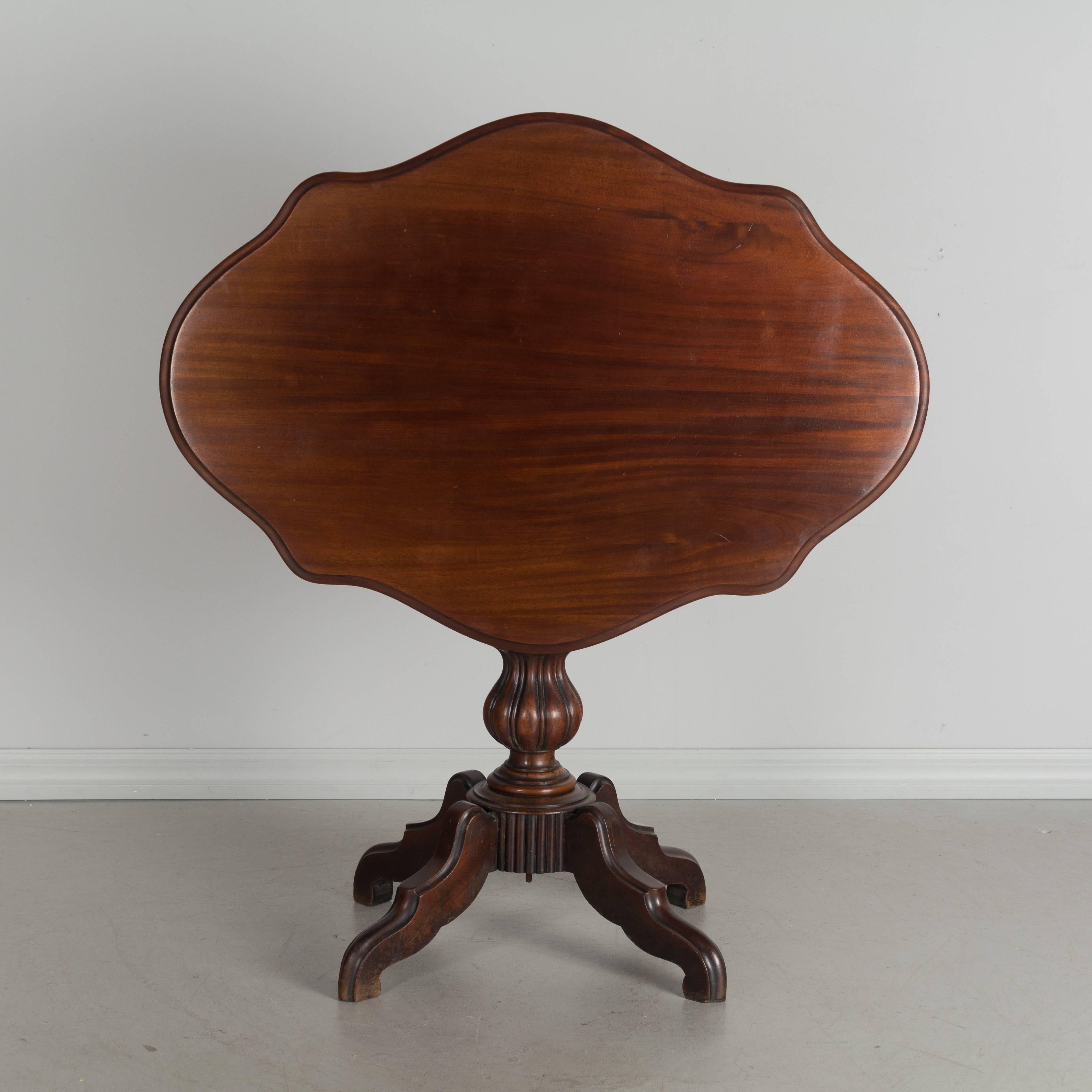 A 19th century, Louis Philippe style gueridon or title-top table made of solid mahogany. Shaped oval top with turned and carved pedestal base. Measures: 45" H when top is tilted up.
More photos available upon request. We have a large selection