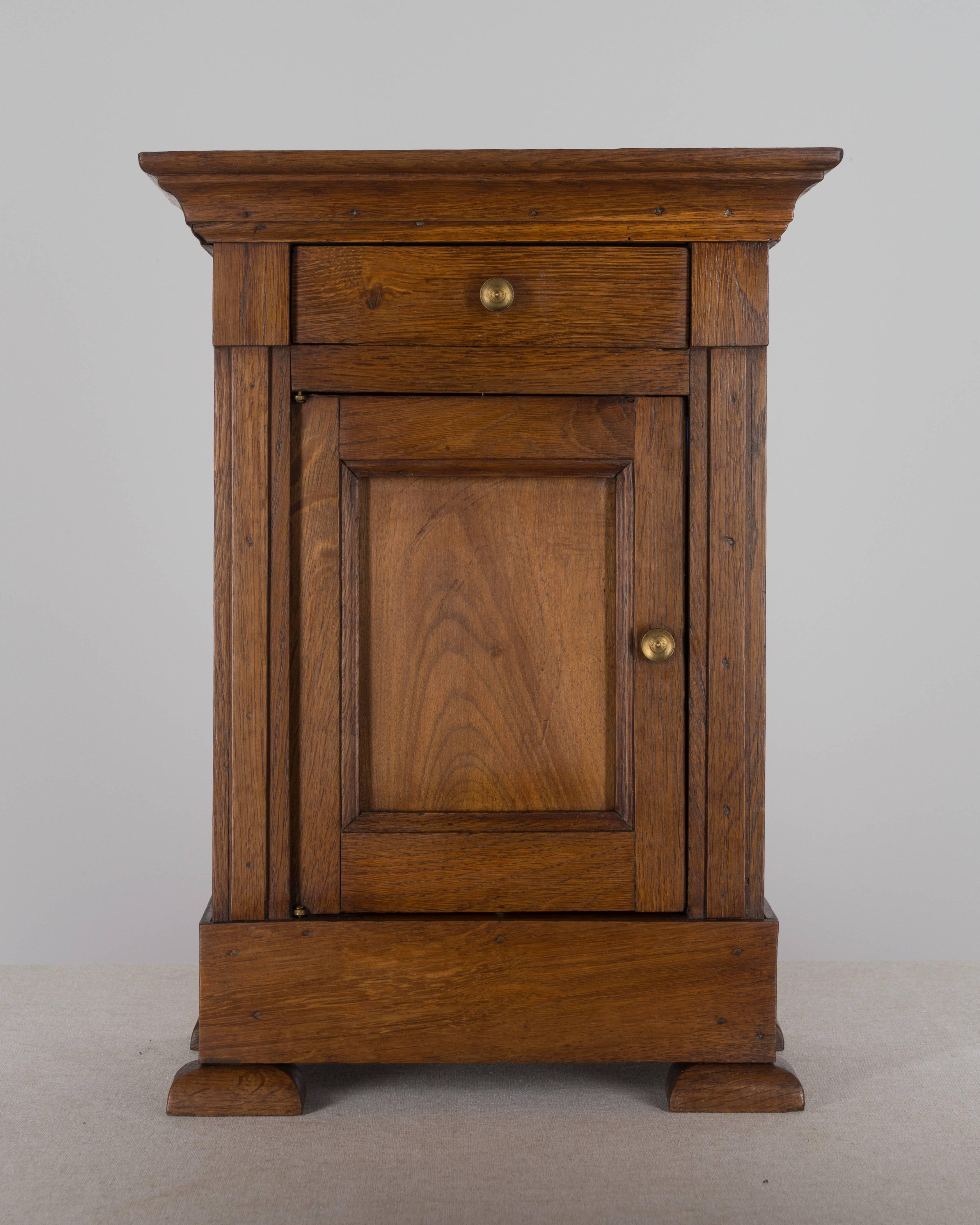 19th century French Louis Philippe miniature cabinet or side table, with a single dovetailed drawer and cabinet door. Made of oak with waxed patina. 17.5" H x 12.5" W x 6.5".
More photos available upon request. We have a large