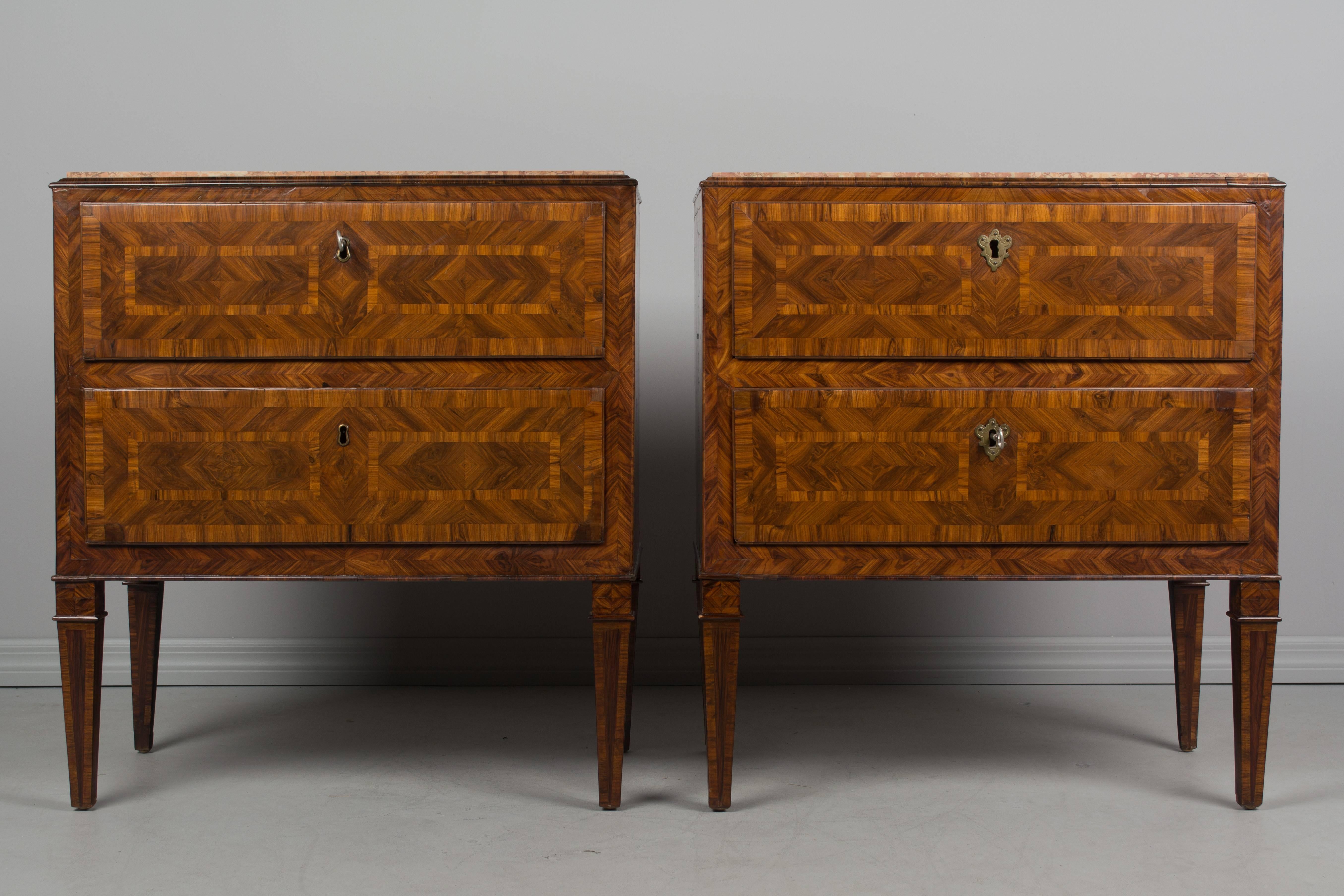 A pair of 18th century Italian commode or small chest of drawers with fine marquetry inlay using veneers of walnut and burl of walnut. French polish finish. Pine as a secondary wood. Two dovetailed drawers on tapered legs. Working locks with two