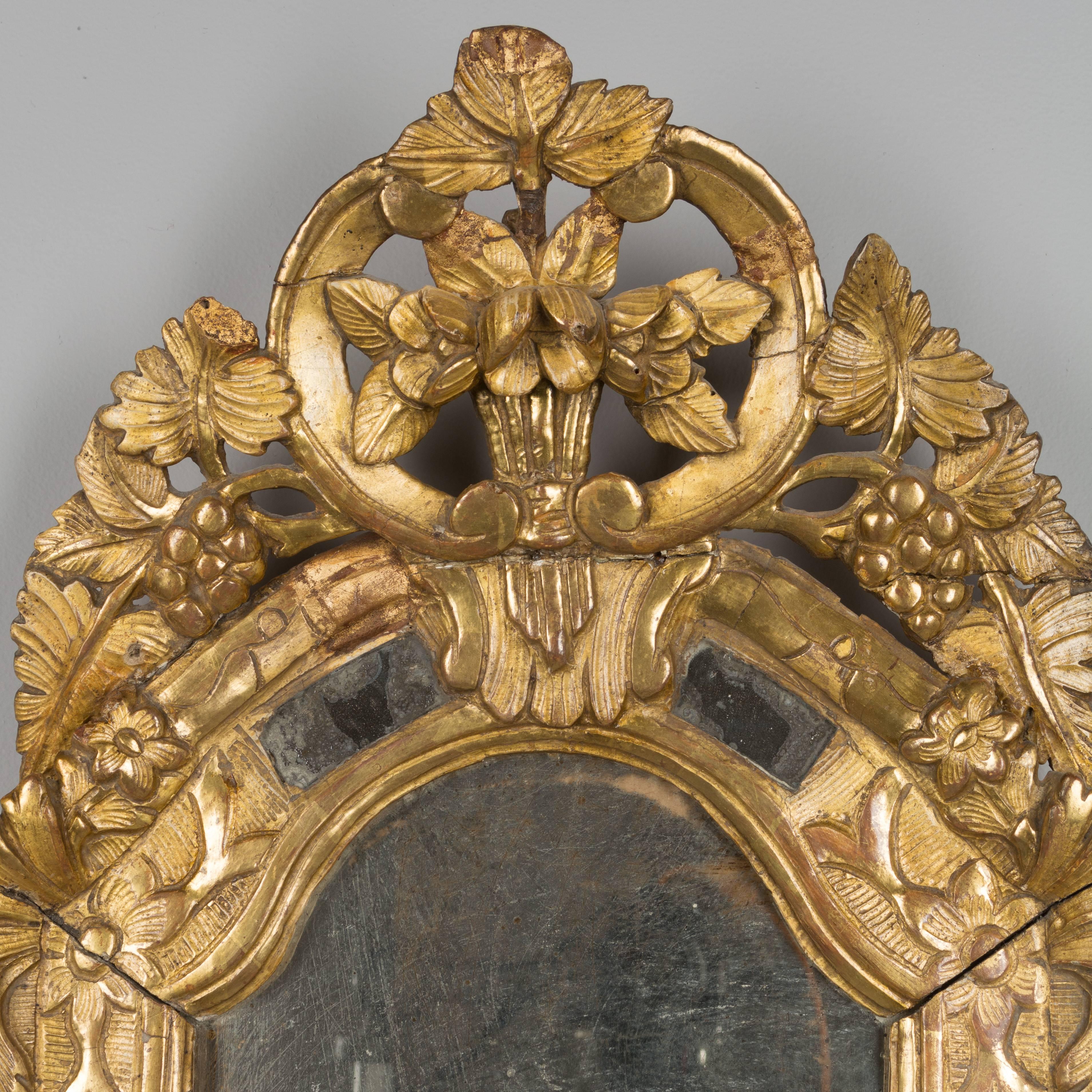 An 18th century. French Regency period gilded wood and gesso mirror. Beautiful carved details. Original looking glass with old silvering. In very good condition for its age with bright gilt and only minor losses. The crest has been reattached and is