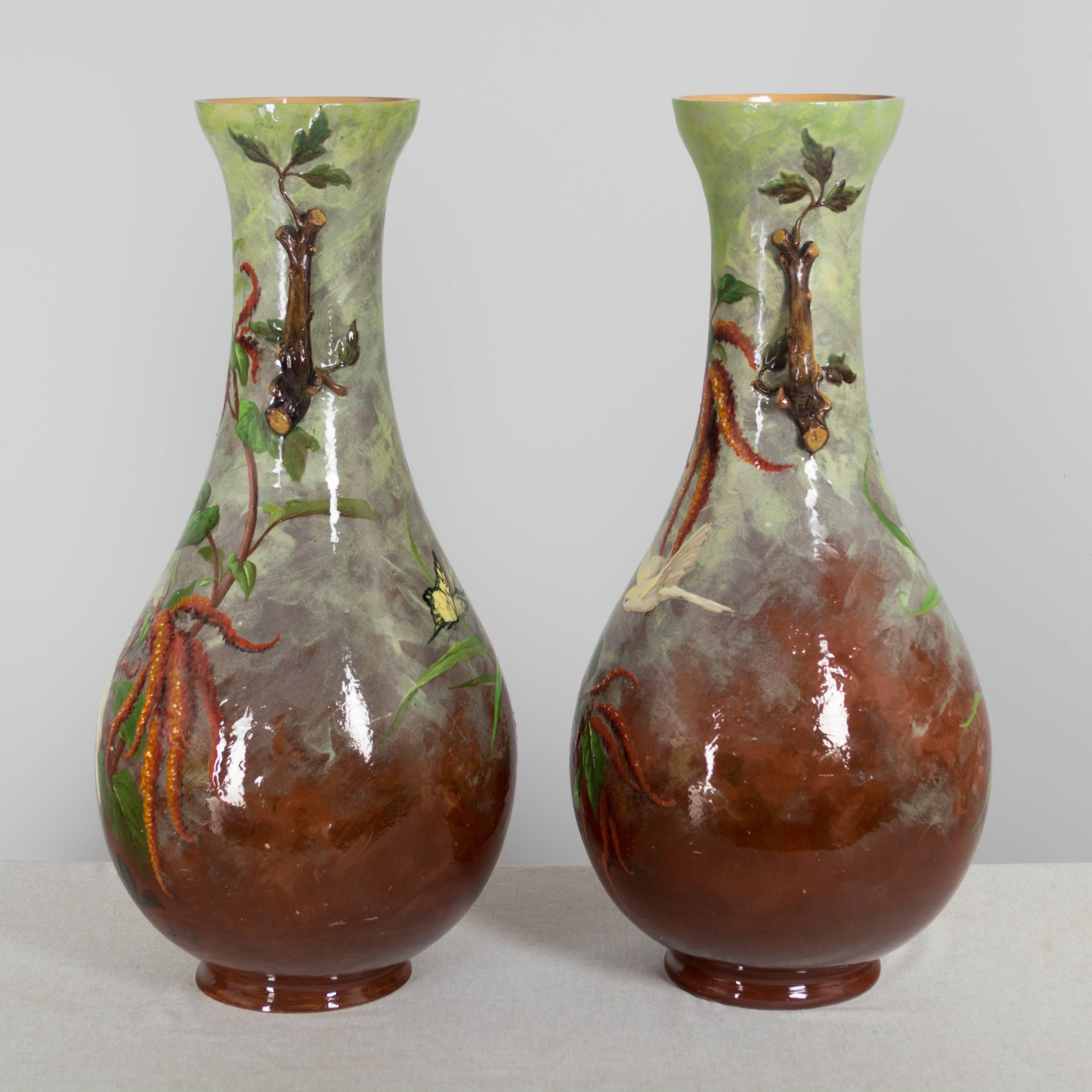 Pair of large French faience vases signed Belat. Beautifully decorated with pale yellow birds on a burgundy and green ground. The rim of one vase has been professionally restored.
Marks on the bottom are numbers.
Each weighs about 19lbs.
More photos