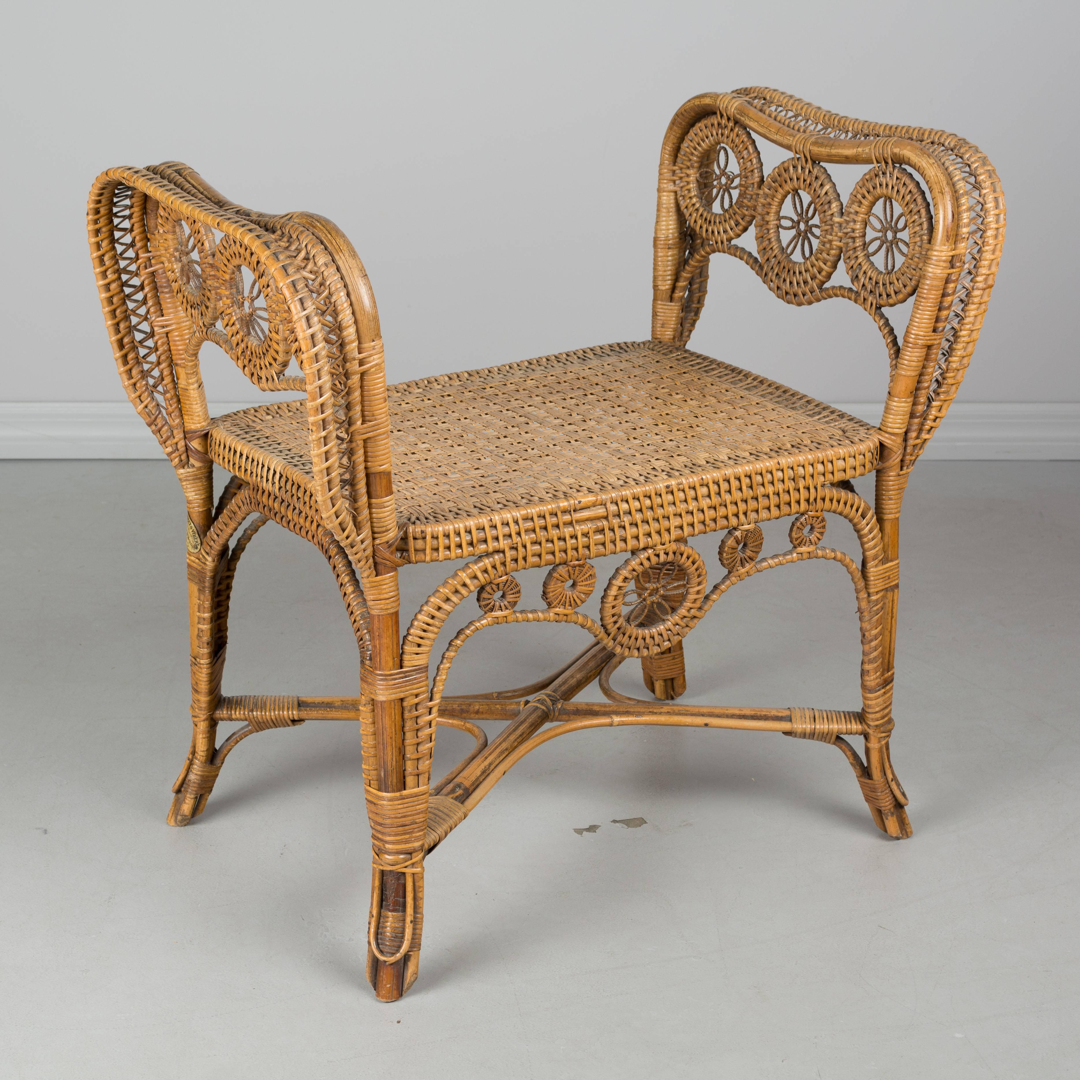 19th century, French wicker bench with bamboo frame. Beautiful scrolling floral design with wide curved sides and tightly woven seat. Sturdy bamboo frame with x-pattern stretcher. Exceptional craftsmanship and with only a few minor losses: petal of