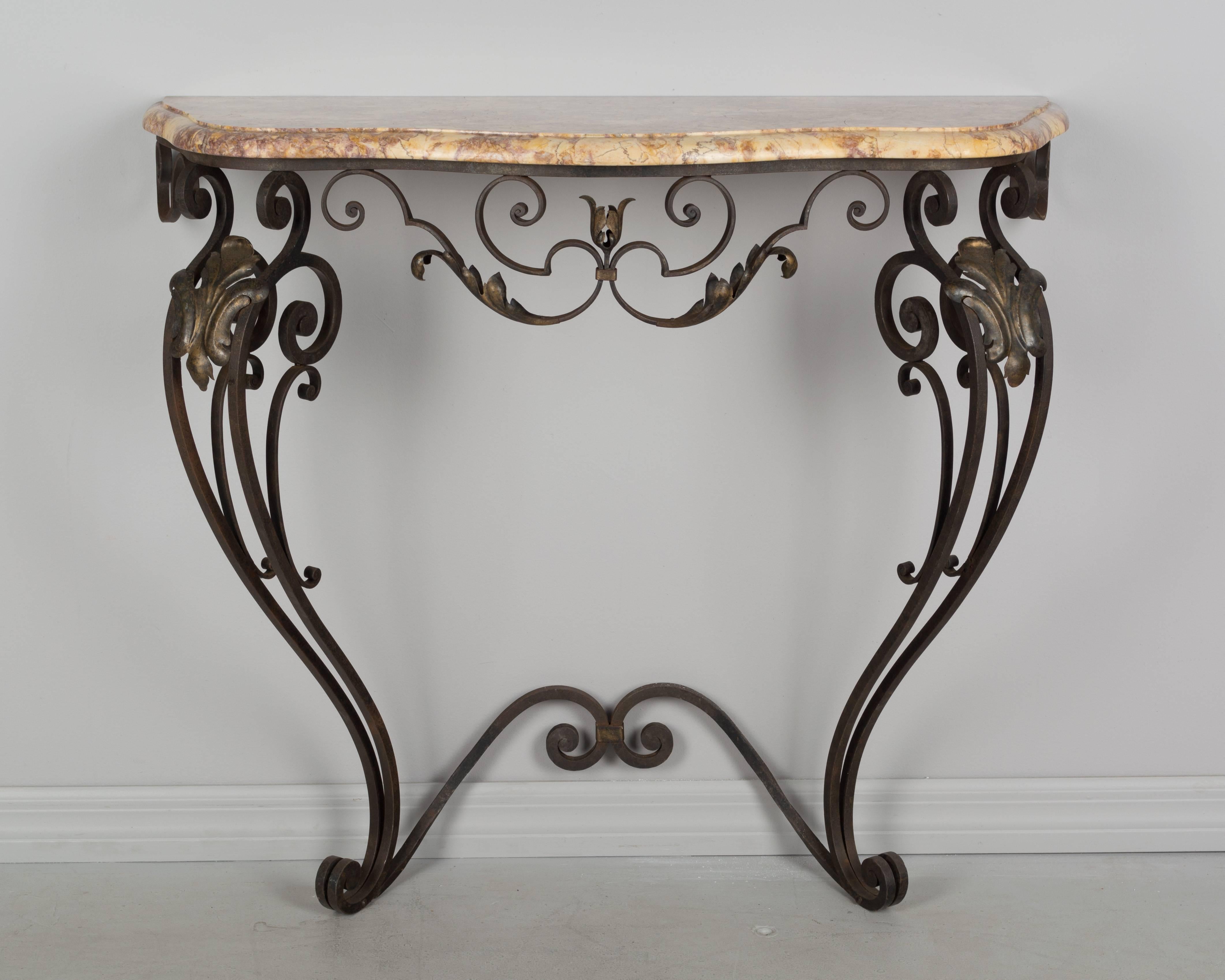 A French Louis XV style wrought iron console table. Decorated with gilt tole acanthus leaves. Original one inch thick marble top.
More photos available upon request. We have a large selection of French antiques. Please visit our showroom in Winter