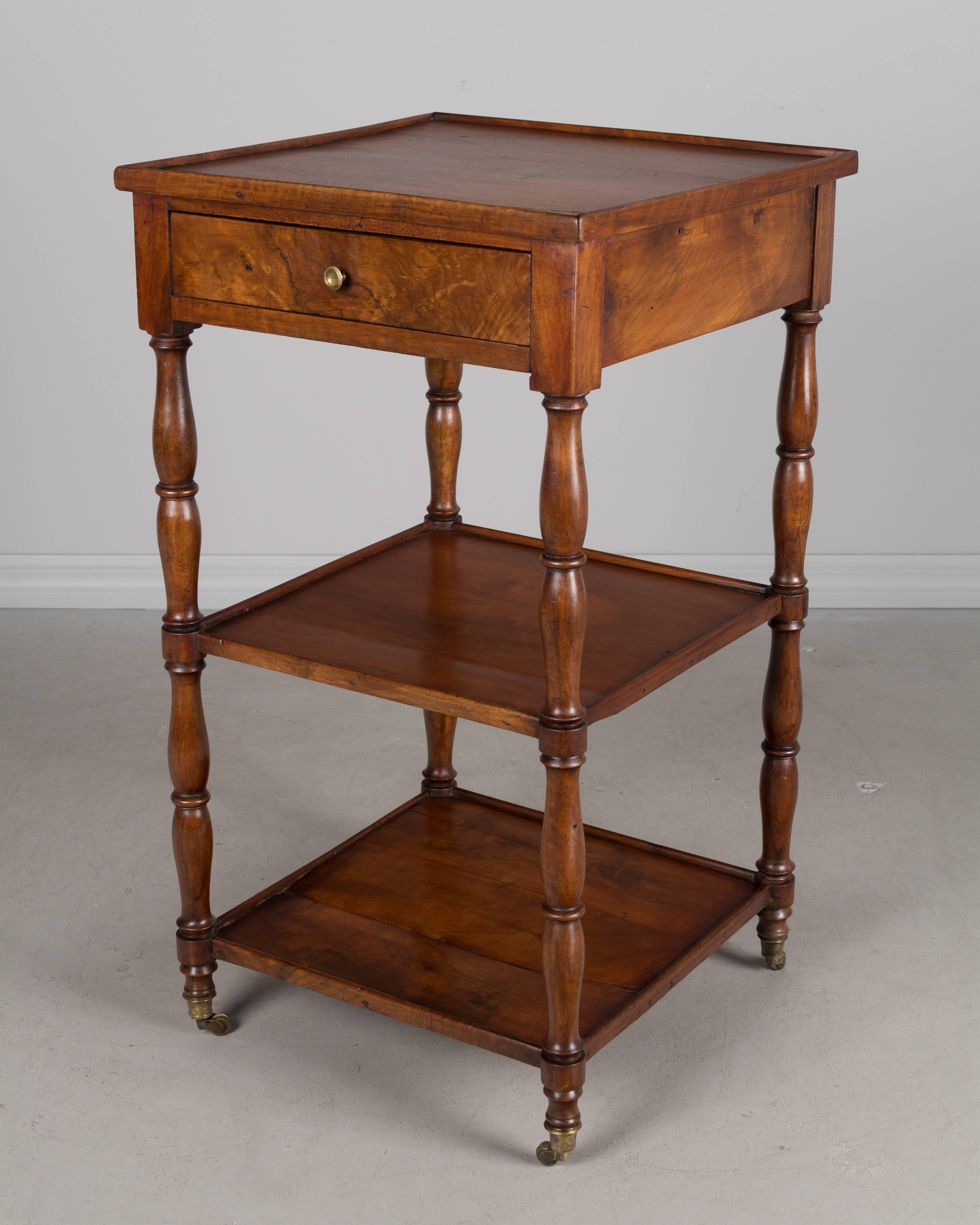 An early 19th century French Louis-Philippe side table or small étagère, made of mahogany with one dovetailed drawer and turned spindles supporting two shelves. Original brass casters. Bottom shelf has been restored.
The bottom shelf is 4.5