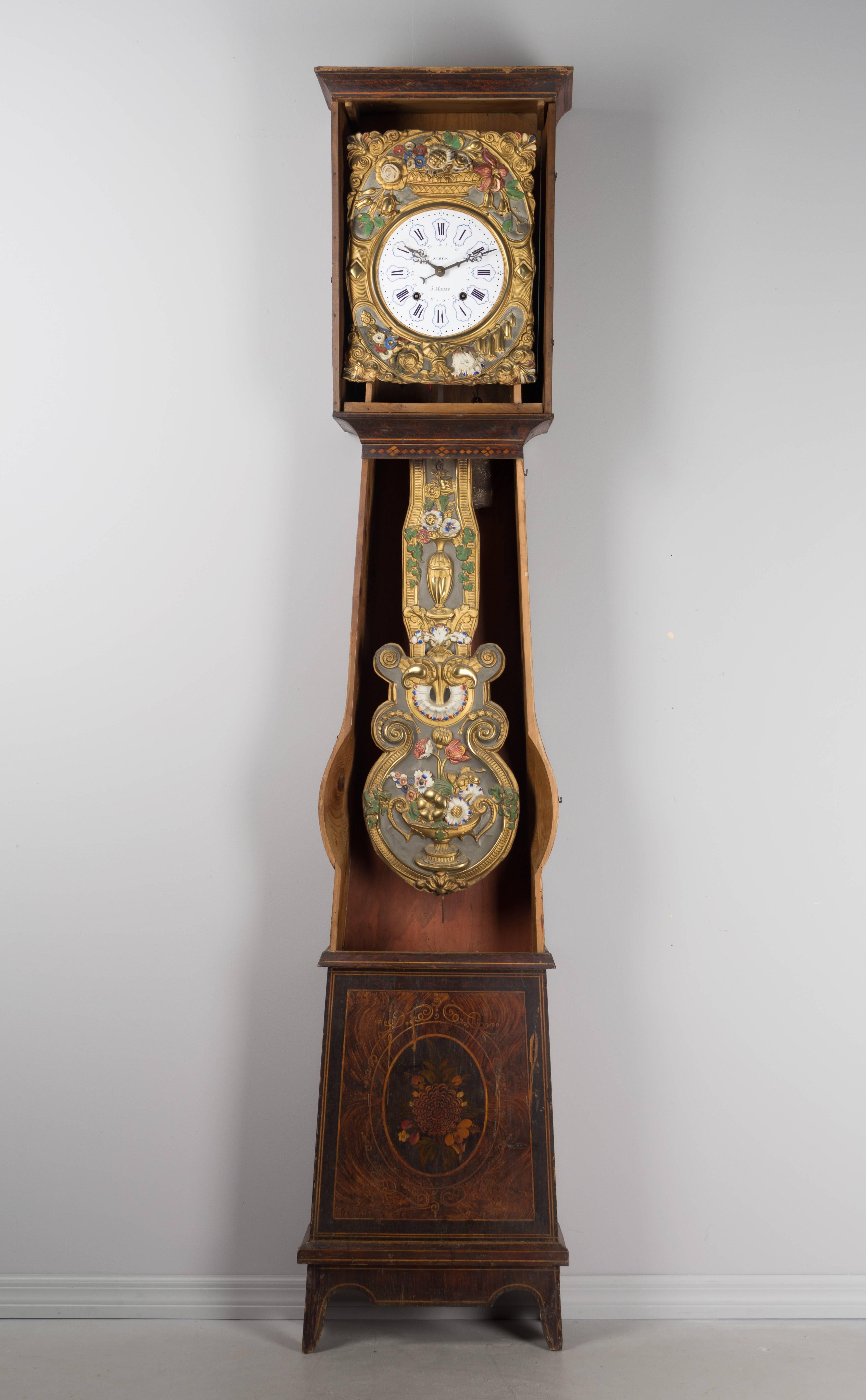 A comtoise or grandfather clock with polychrome painted pine case and brass embossment. The pendulum and clockface surround are beautifully decorated with floral motif and retain the original painted surface. Seven day Morbier movement with date, in