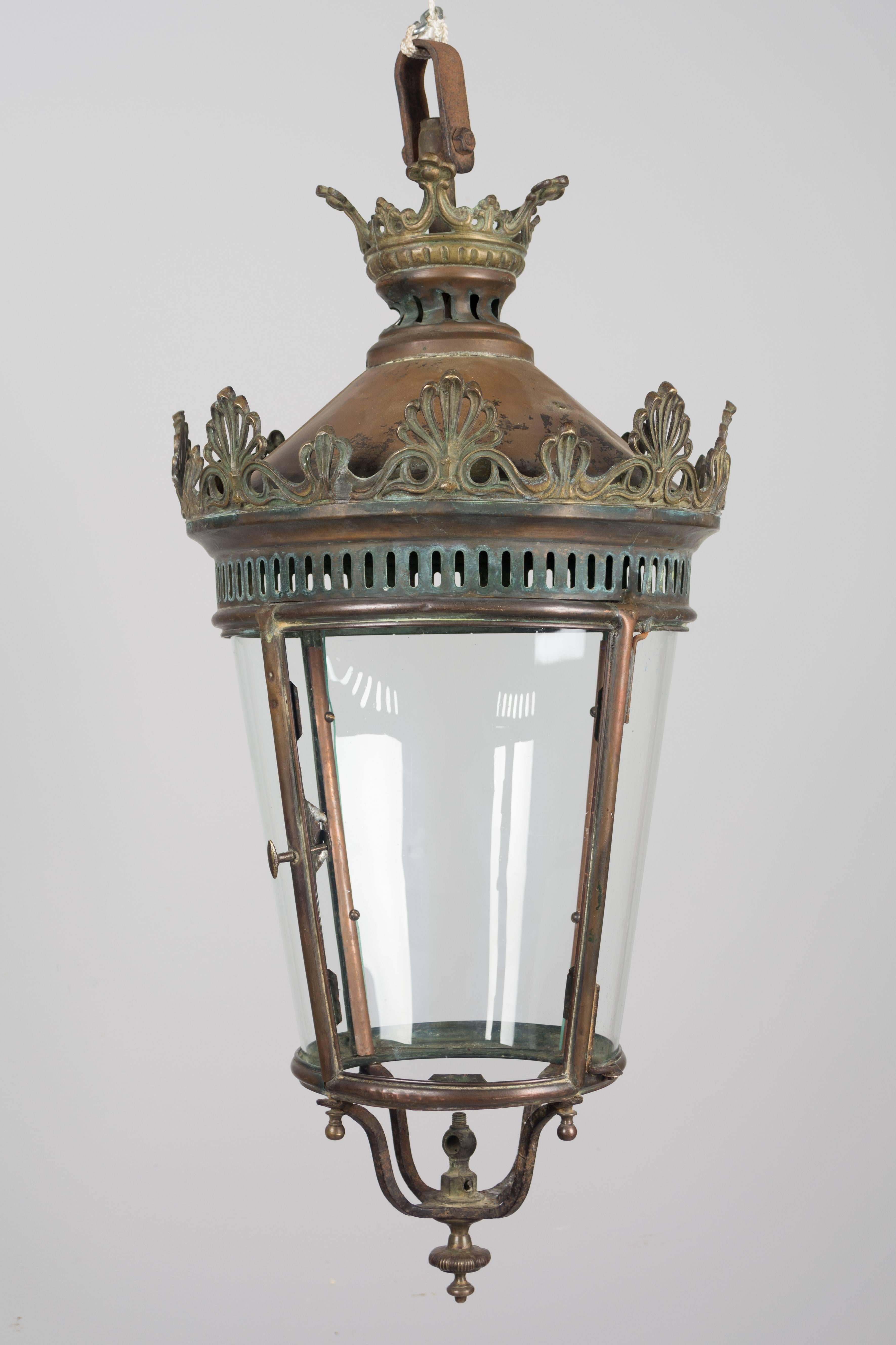 A 19th century French bronze and copper hanging lantern with new handblown curved glass and hinged door. Beautiful old patina. This was once a gas light and may be wired. Overall dimensions including the large loop at the top: 38" H x 16"