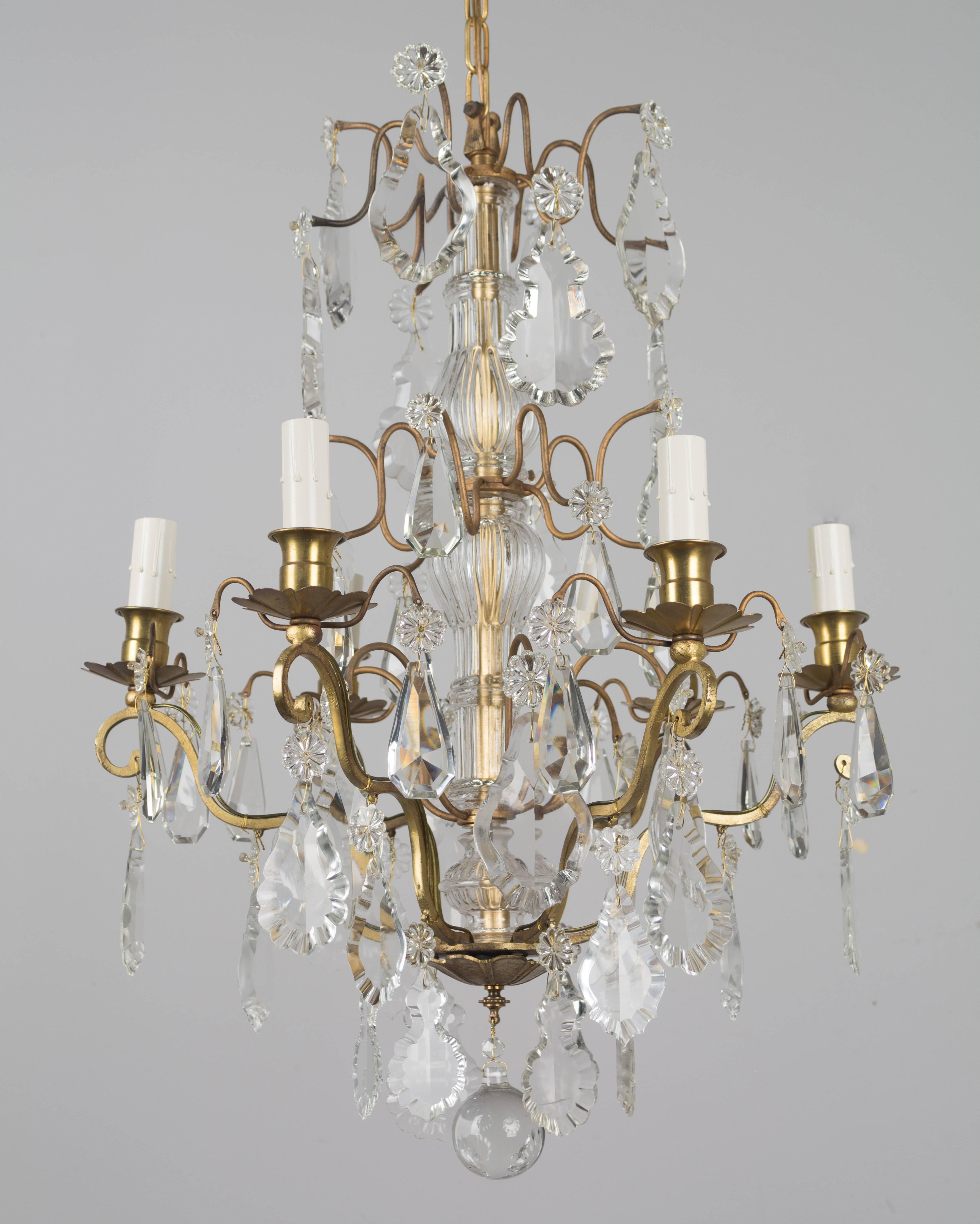 French six-light chandelier with an assortment of crystal prisms, columns and rosettes. Brass frame. Rewired with new sockets and candle covers. Measures: 24" height x 18" diameter. Height to top of canopy is 38"
More photos