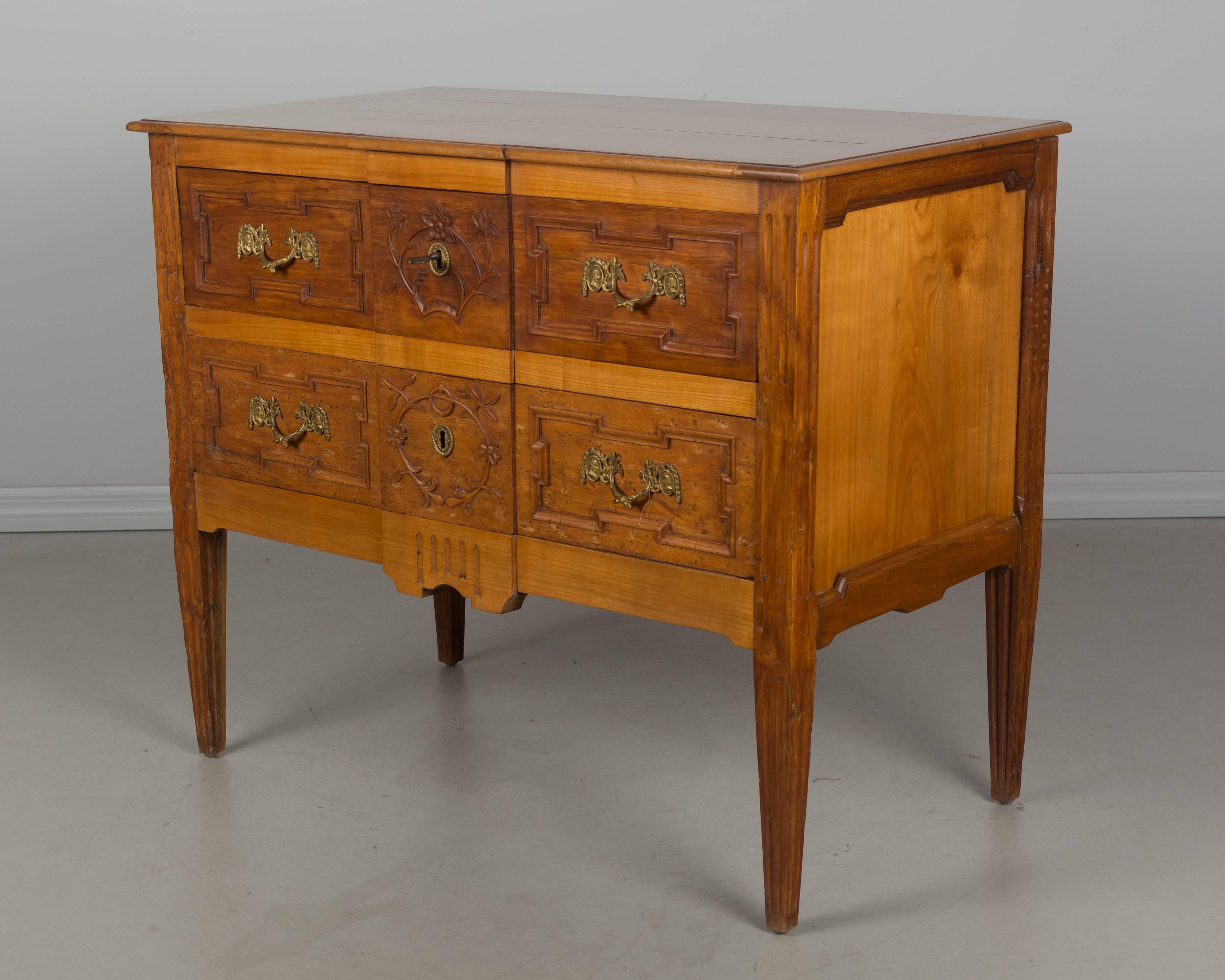 A fine 20th century Louis XVI style commode made of cherry and walnut with two dovetailed drawers. Original bronze hardware and lock and key in working order. Minor restoration on back legs.
More photos available upon request. We have a large