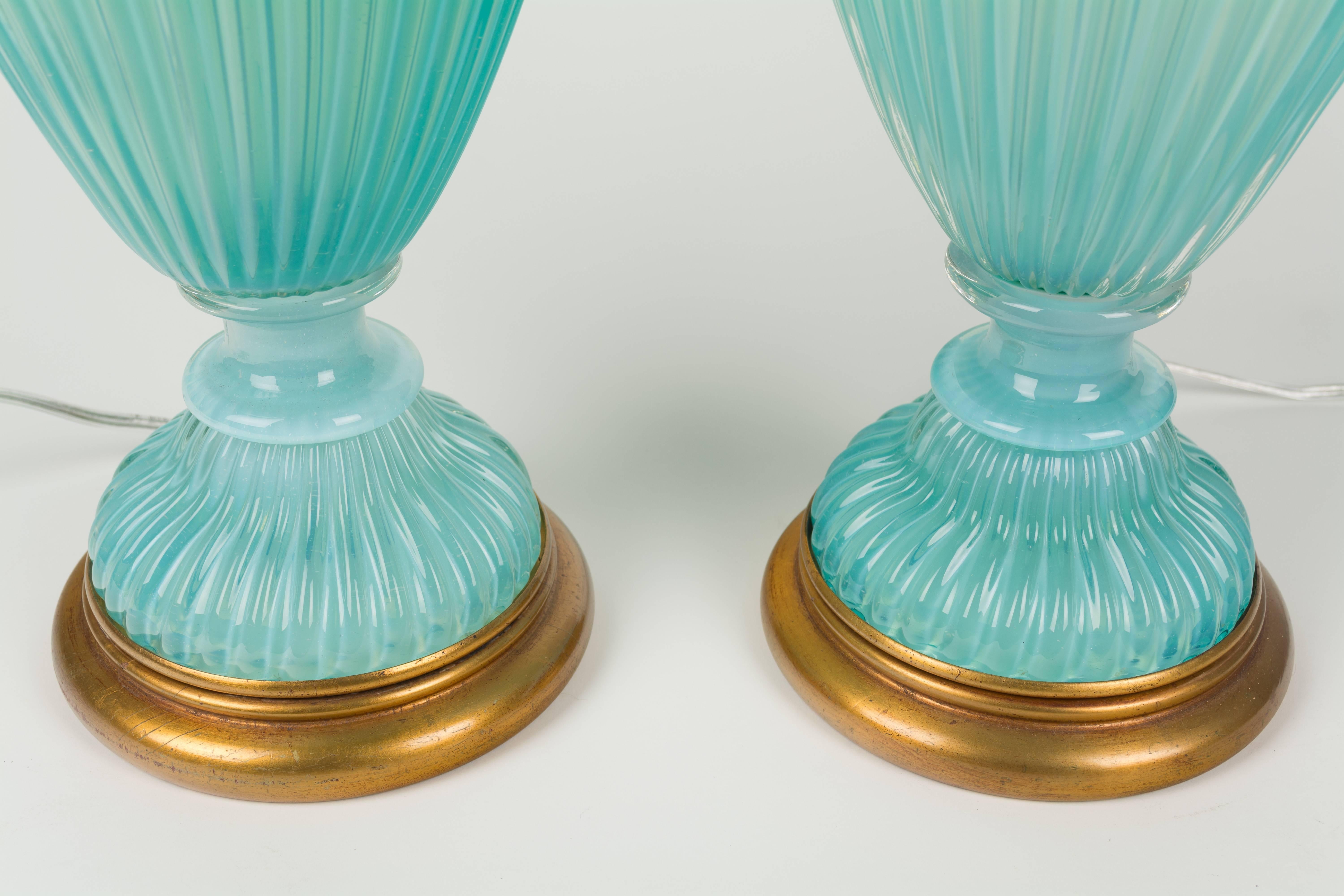 Pair of large aqua blue Murano glass table lamps by Archimede Seguso for The Marbro Lamp Company. Handblown glass is in three parts with ribbed body. Gorgeous opalescent color is similar to Tiffany blue. Elegant Hollywood Regency style with gold