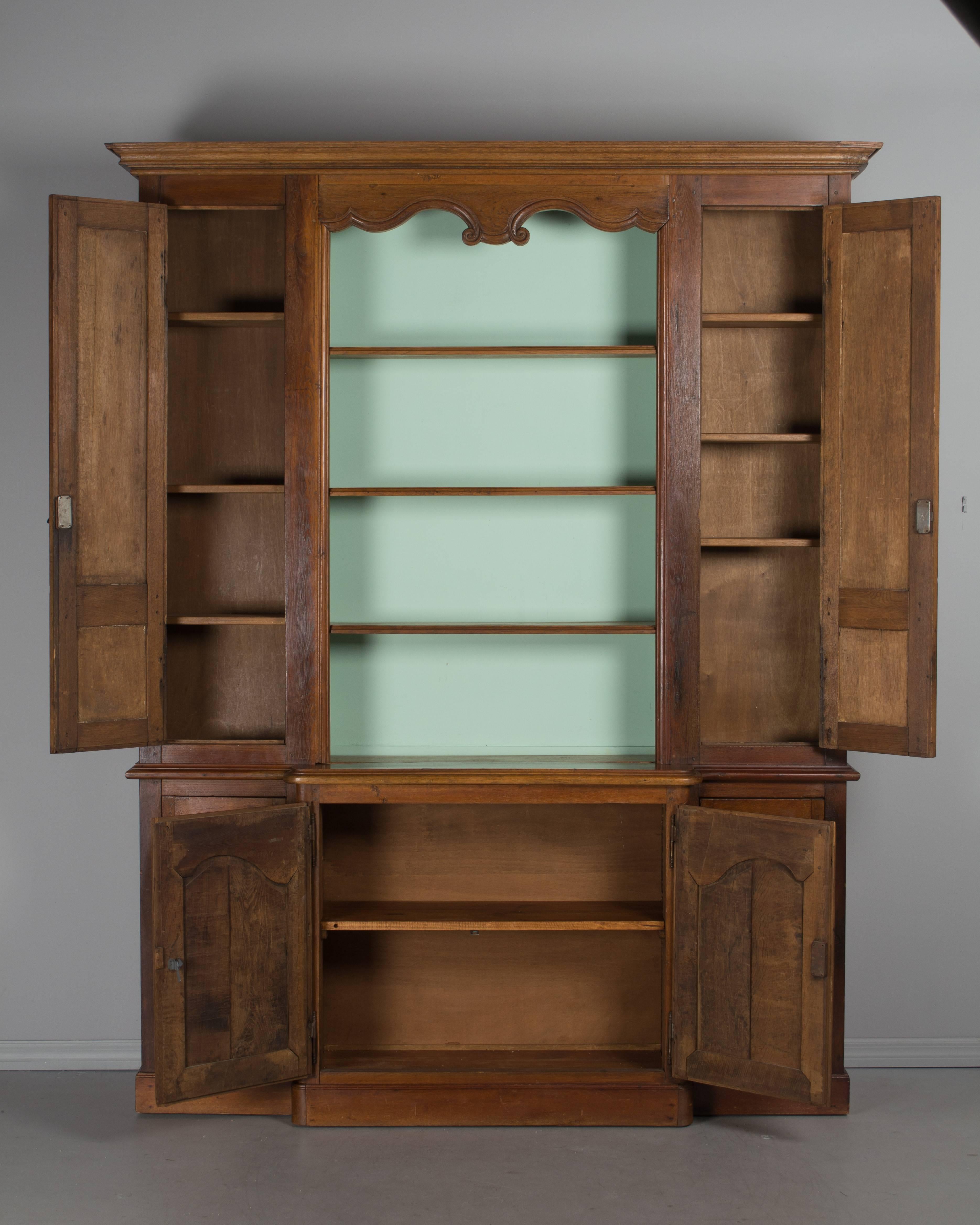 A 19th century Country French biblioteque, or bookcase, made of oak and in three parts. The center is newly painted and has three fixed shelves that measure 7.5