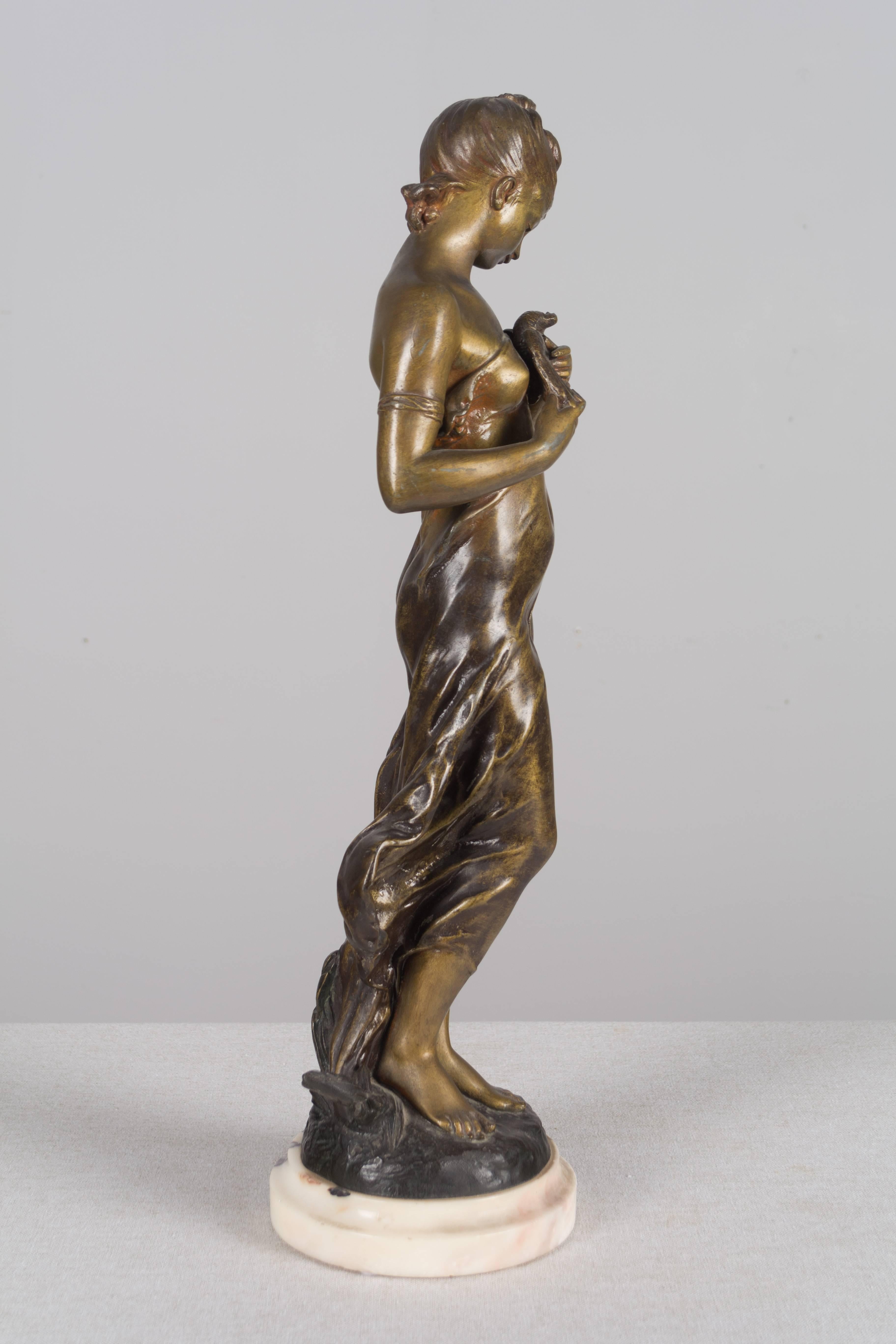 A 19th century French sculpture by Hippolyte Moreau (1832 – 1927) entitled L'Oiseau Blessé depicting a beautiful young girl holding a dove. A pot metal statue with a patina made to look like bronze. Marble base. Signed Hip. Moreau. Weight: 9 lbs.