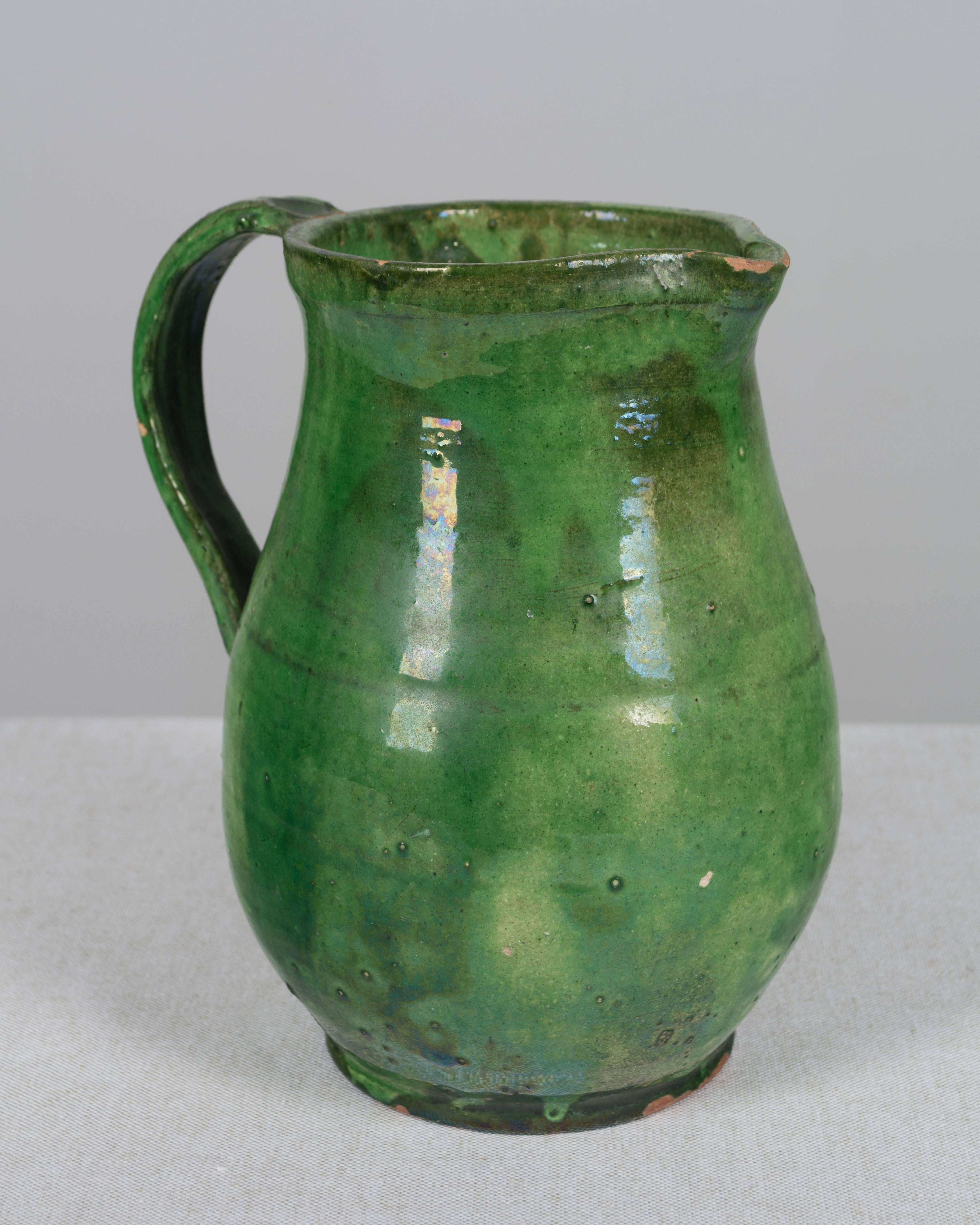 A 19th century French terracotta pitcher with beautiful green glaze. From the Southwest of France. Hairline crack and minor losses, circa 1840-1860. Measures: 8.25