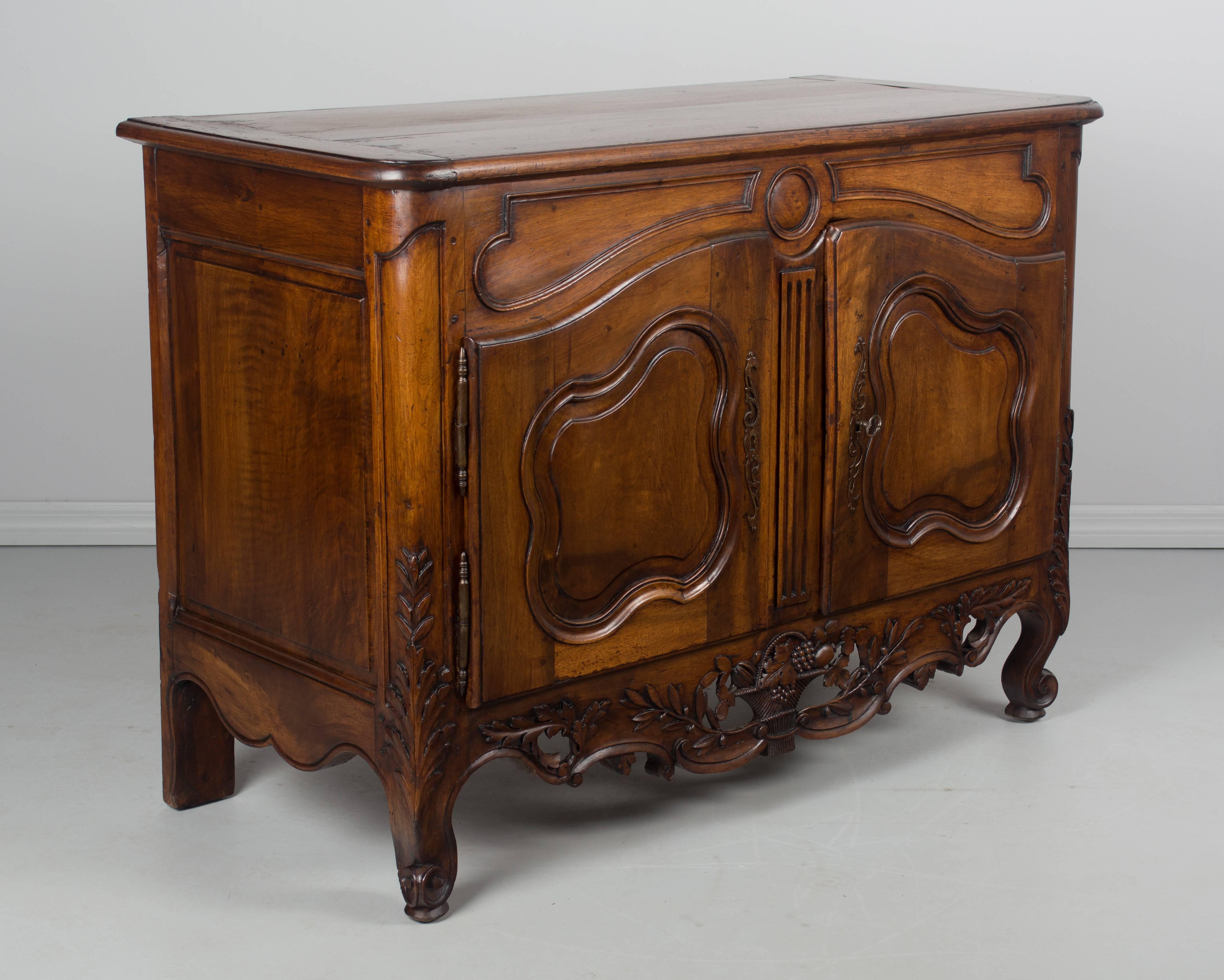 A buffet made of walnut from the Provence region from the last quarter of the 18th century. This was once a dough box with the top sliding forward. The box has been removed to allow for more storage. A beautiful buffet with two arched doors above a