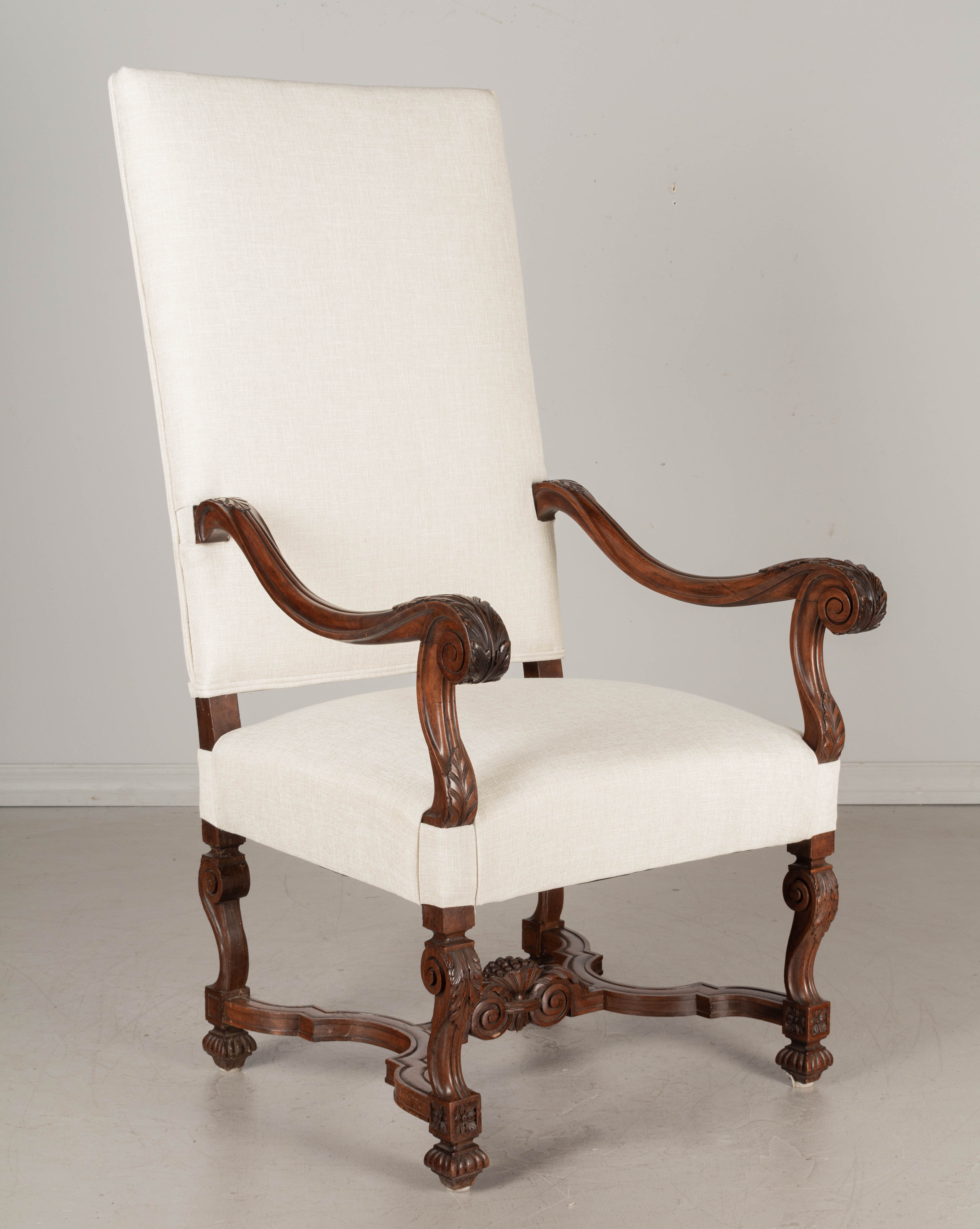 A 19th century Louis XIII style French fauteuil, or armchair, made of solid walnut. Beautiful hand carved details including sculptural scrolled arms and legs with acanthus leaves, and X-form stretcher with center decoration. Great quality frame.