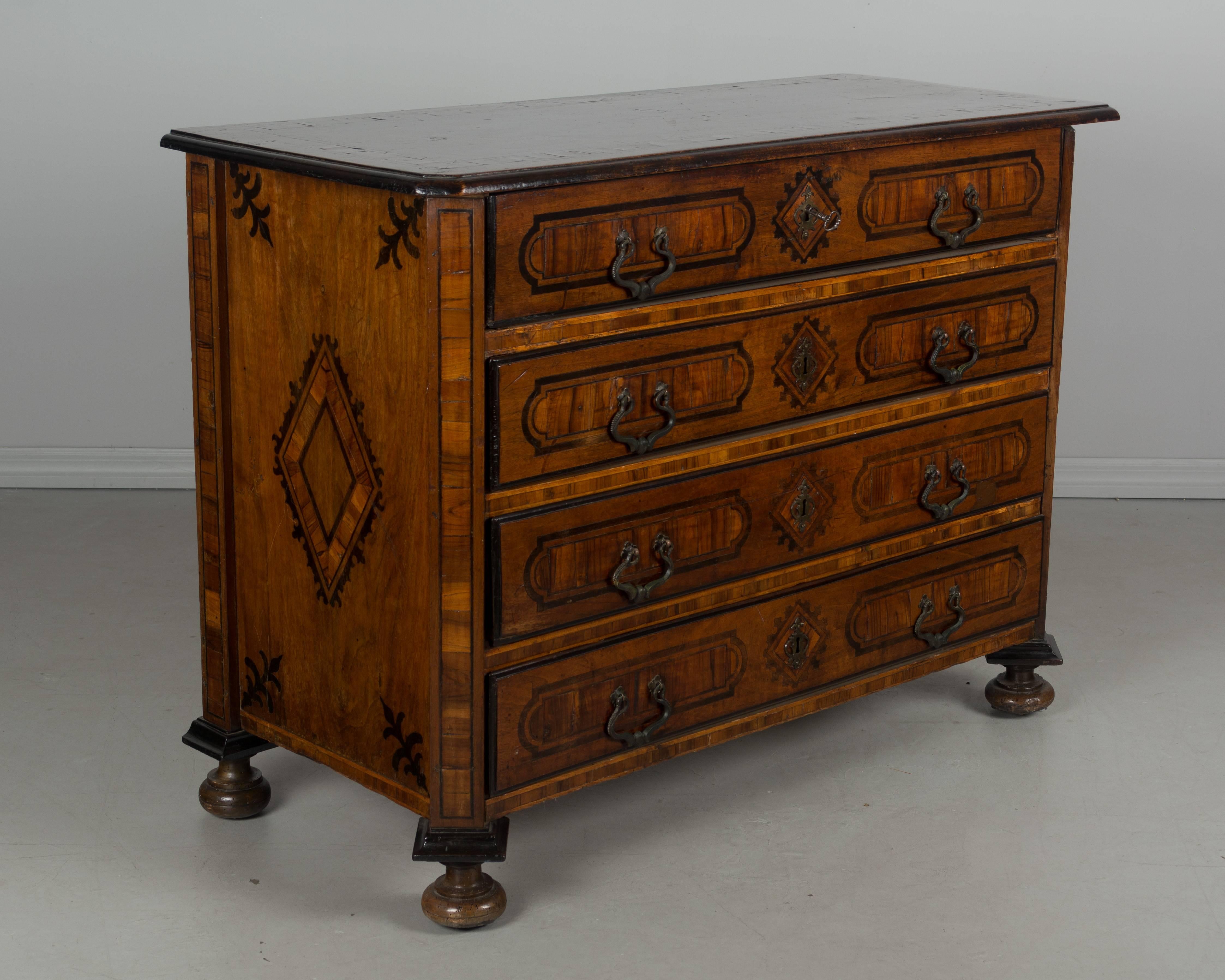 18th century Italian marquetry commode with three drawers and a top drawer that pulls out to reveal a desk. Exceptional craftsmanship for this Piedmont (Northern Italy) chest, made of solid walnut, with walnut veneer and various ebonized wood