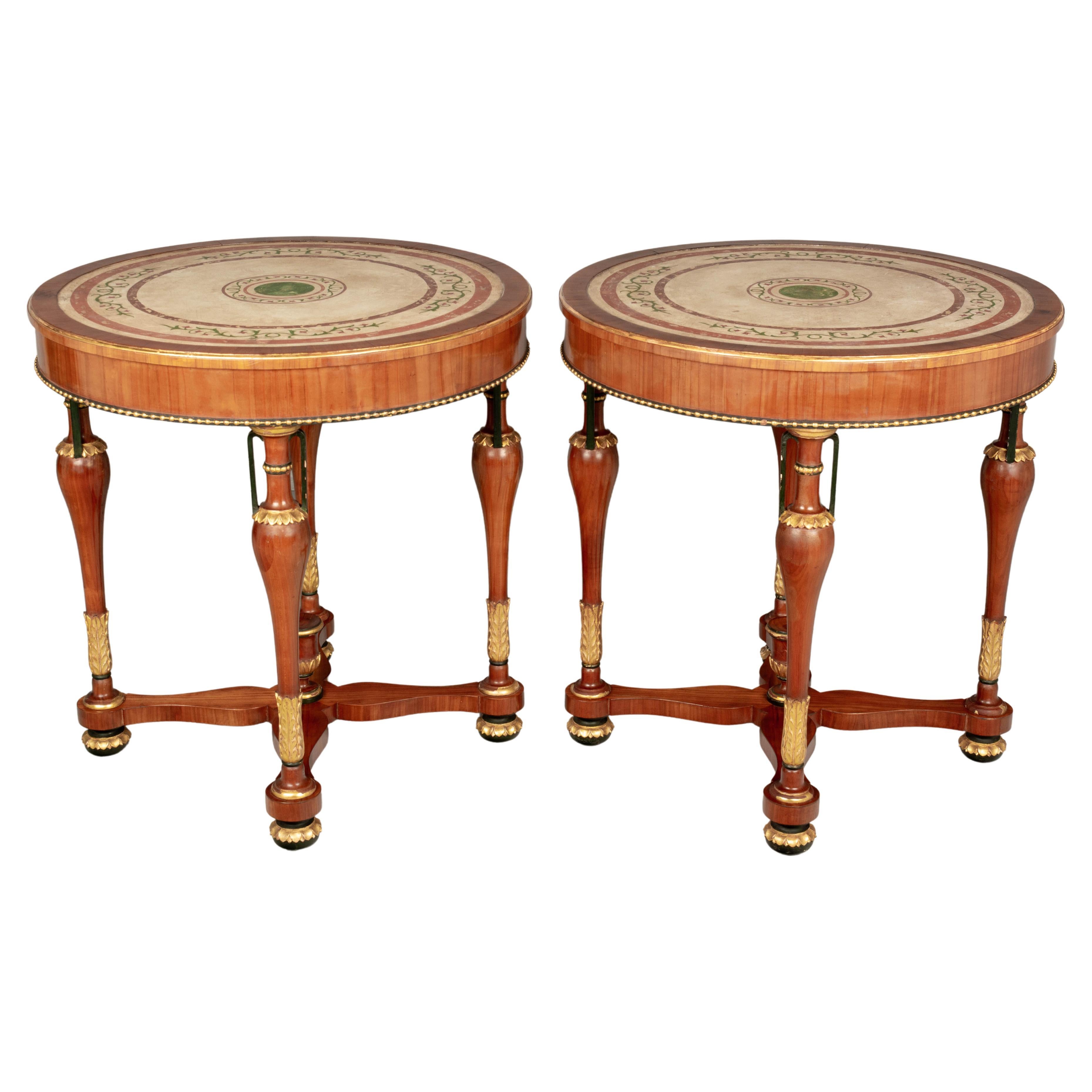 A pair of Italian Neoclassical circular center tables made of solid and veneer of cherry. The tops are scagliola, a hand-painted plaster technique that resembles inlays in marble. Elegant turned legs with urn forms and gilded foliate decoration with