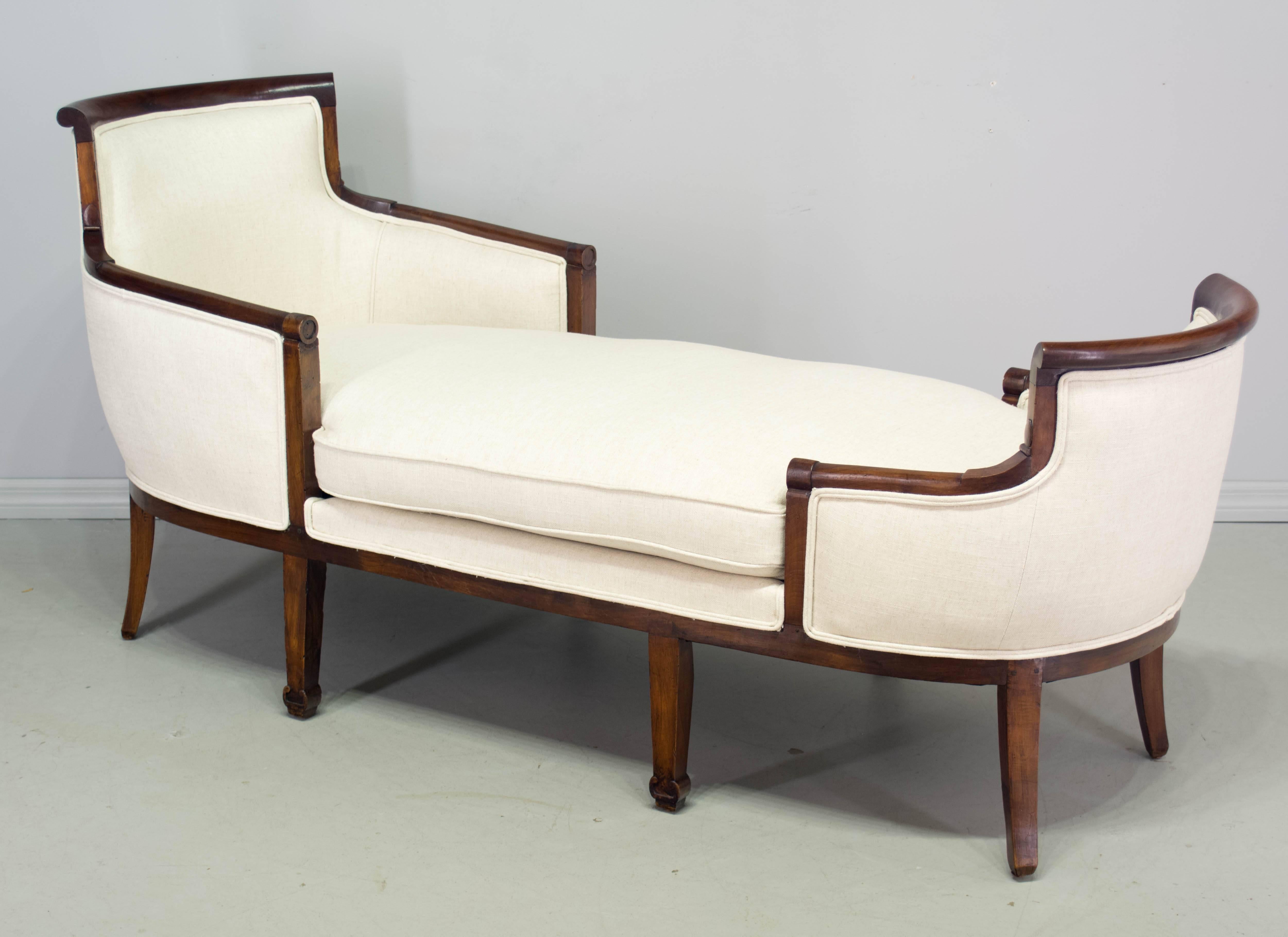 An original Empire chaise longue with a solid walnut frame and pegged construction. Strong and sturdy, resting on eight legs. Nice proportions and subtle detail on the armrests and feet. Gorgeous patina. Upholstered in a linen blend fabric with down